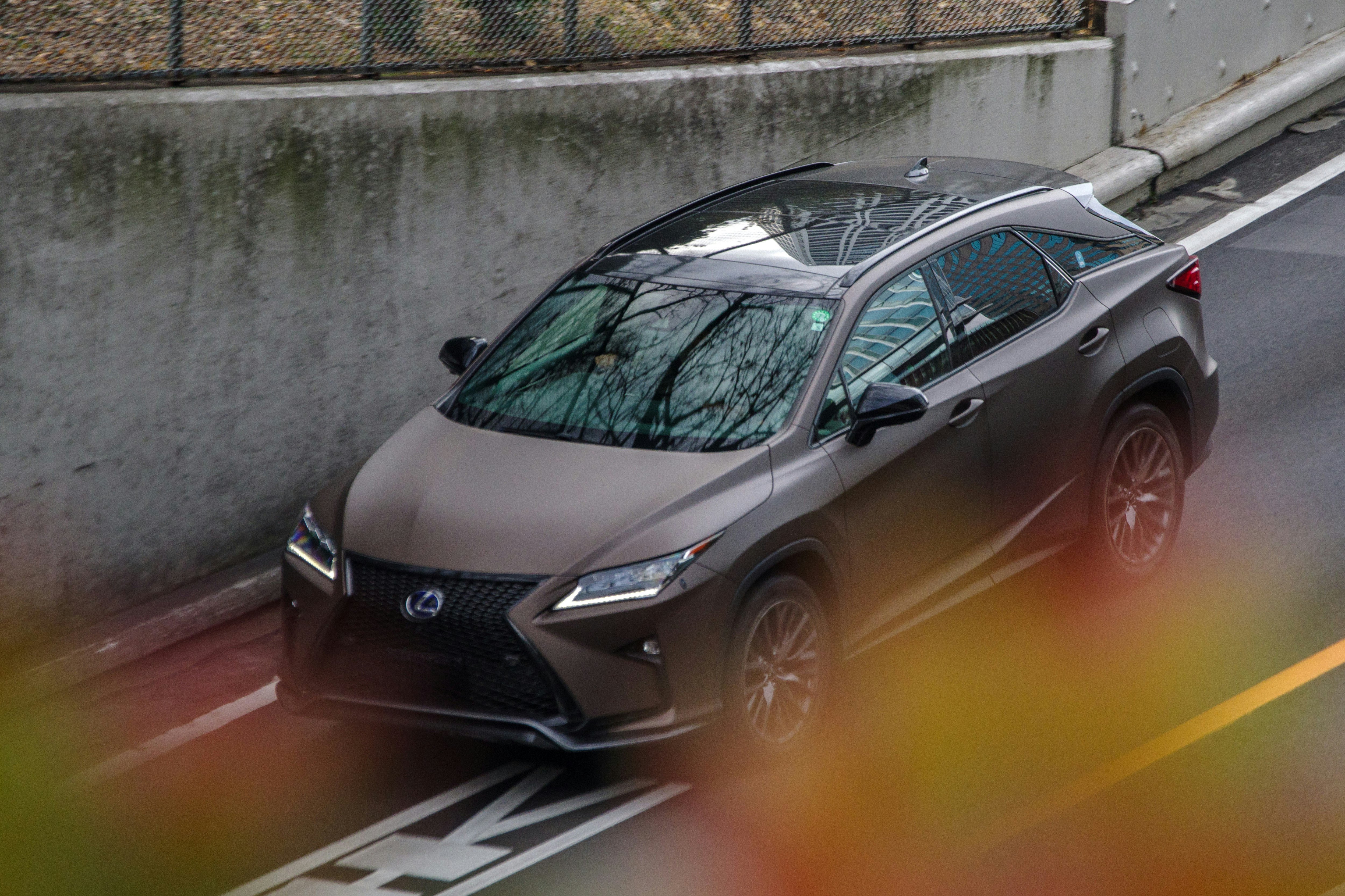Auto Lexus che guida lungo una strada vicino a un muro