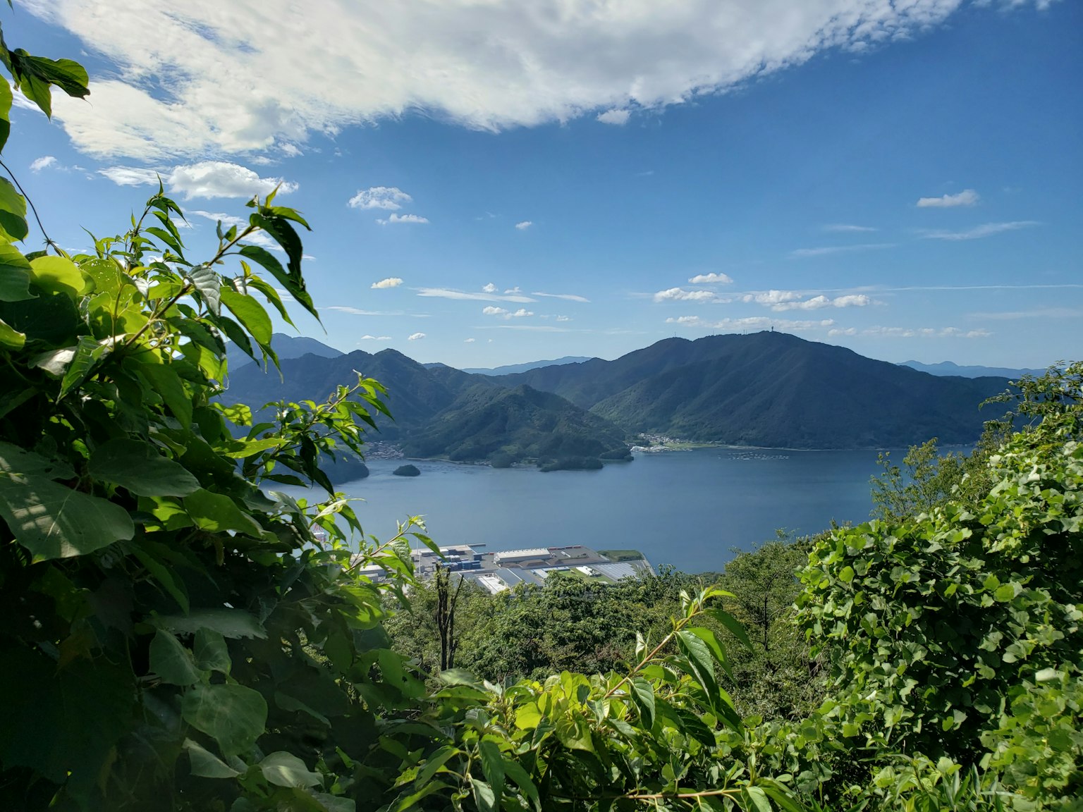 Vista panoramica di montagne e lago circondato da vegetazione lussureggiante