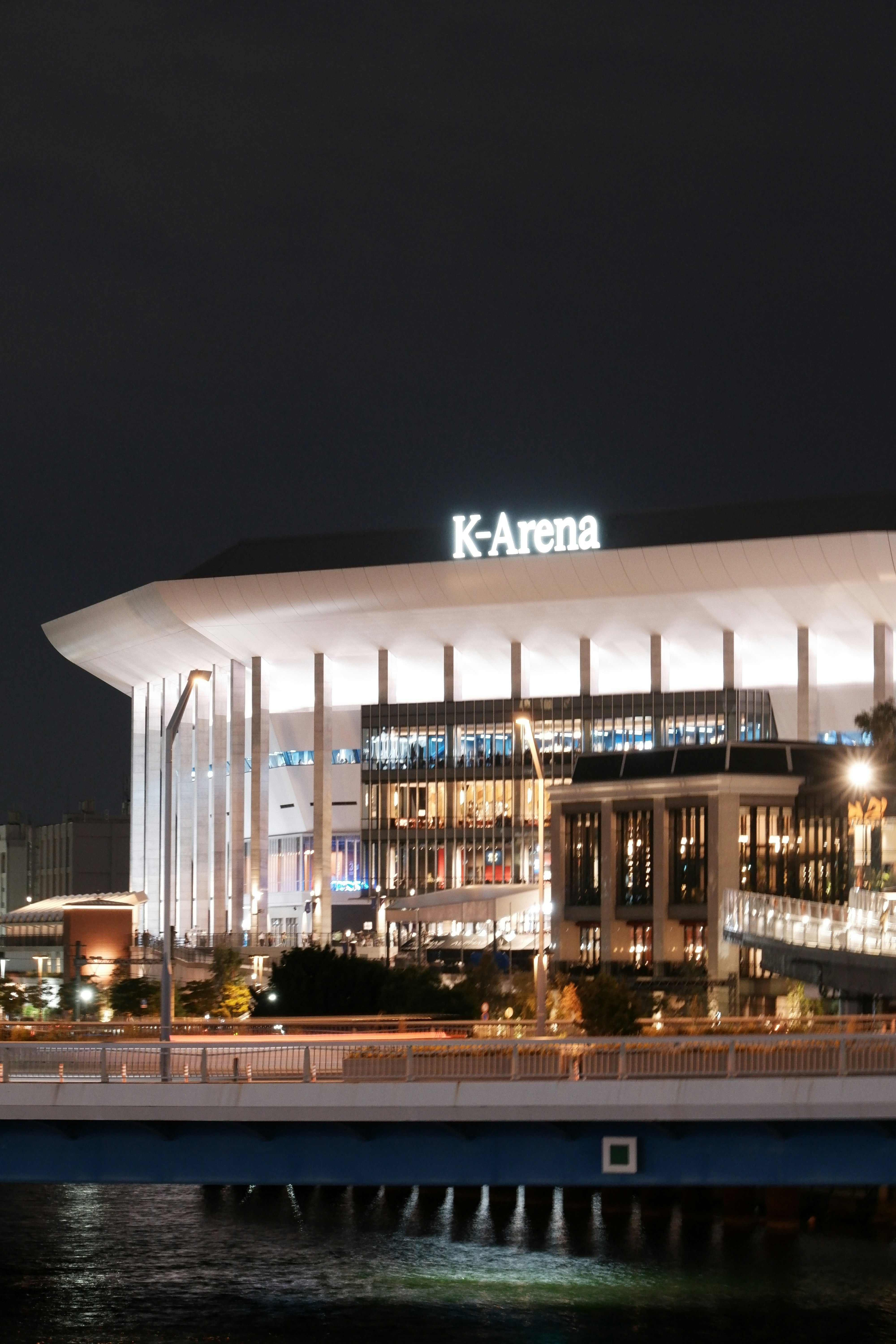 夜の海上に浮かぶK-Arenaの建物外観