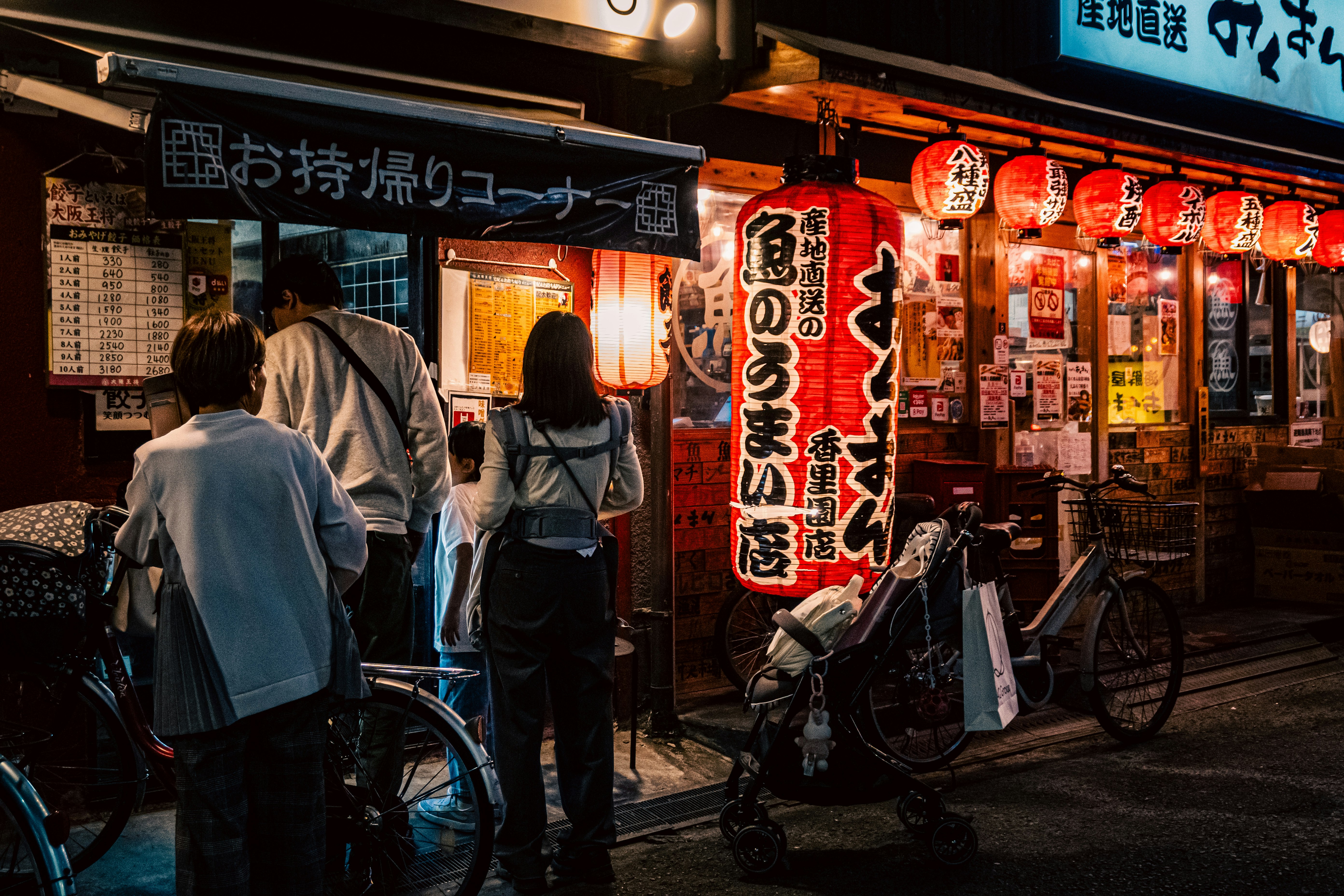 路地の屋台風の提灯と自転車が並ぶ飲食店街の軒先