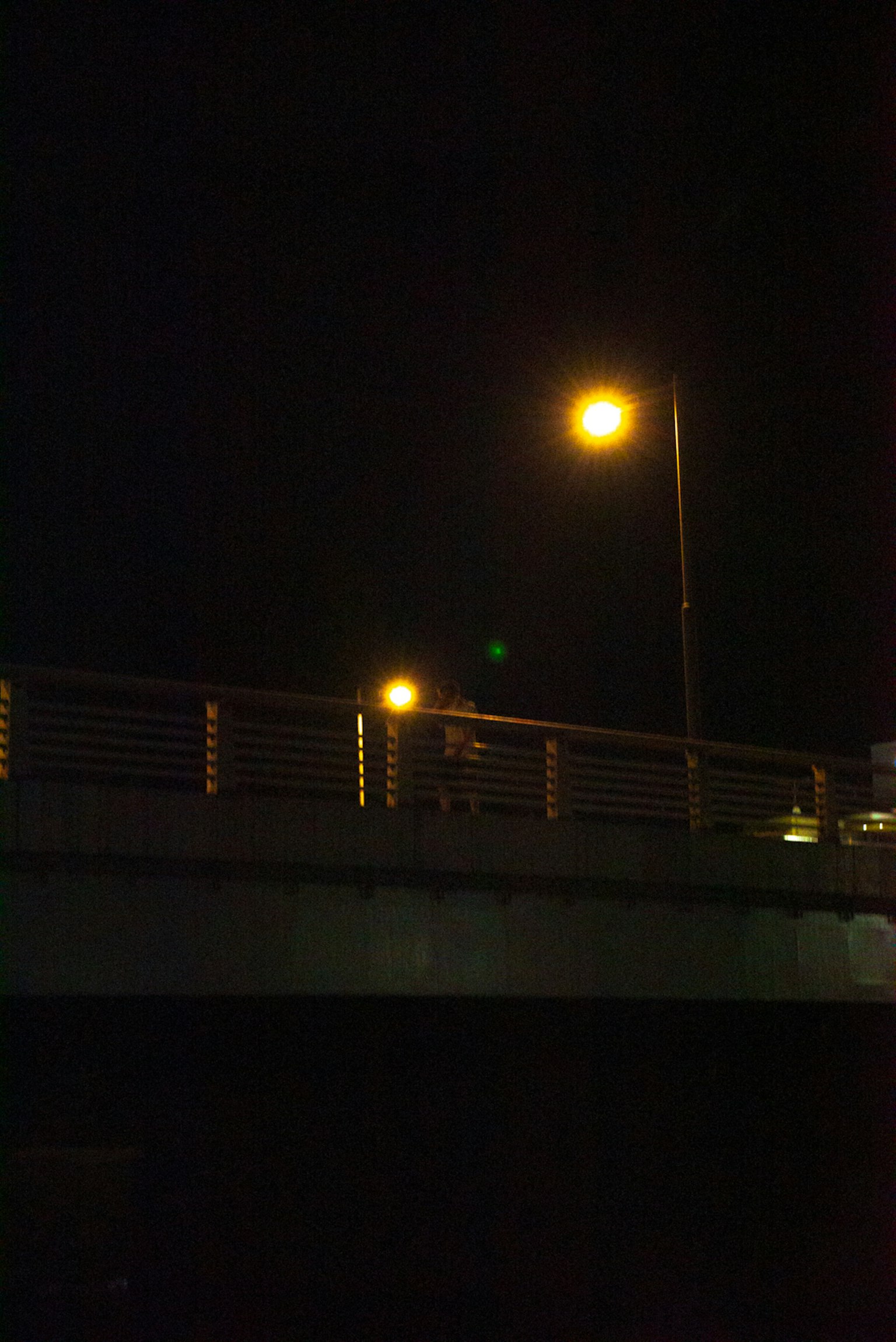 Straßenlaternen auf einer Brücke bei Nacht mit dunklem Hintergrund