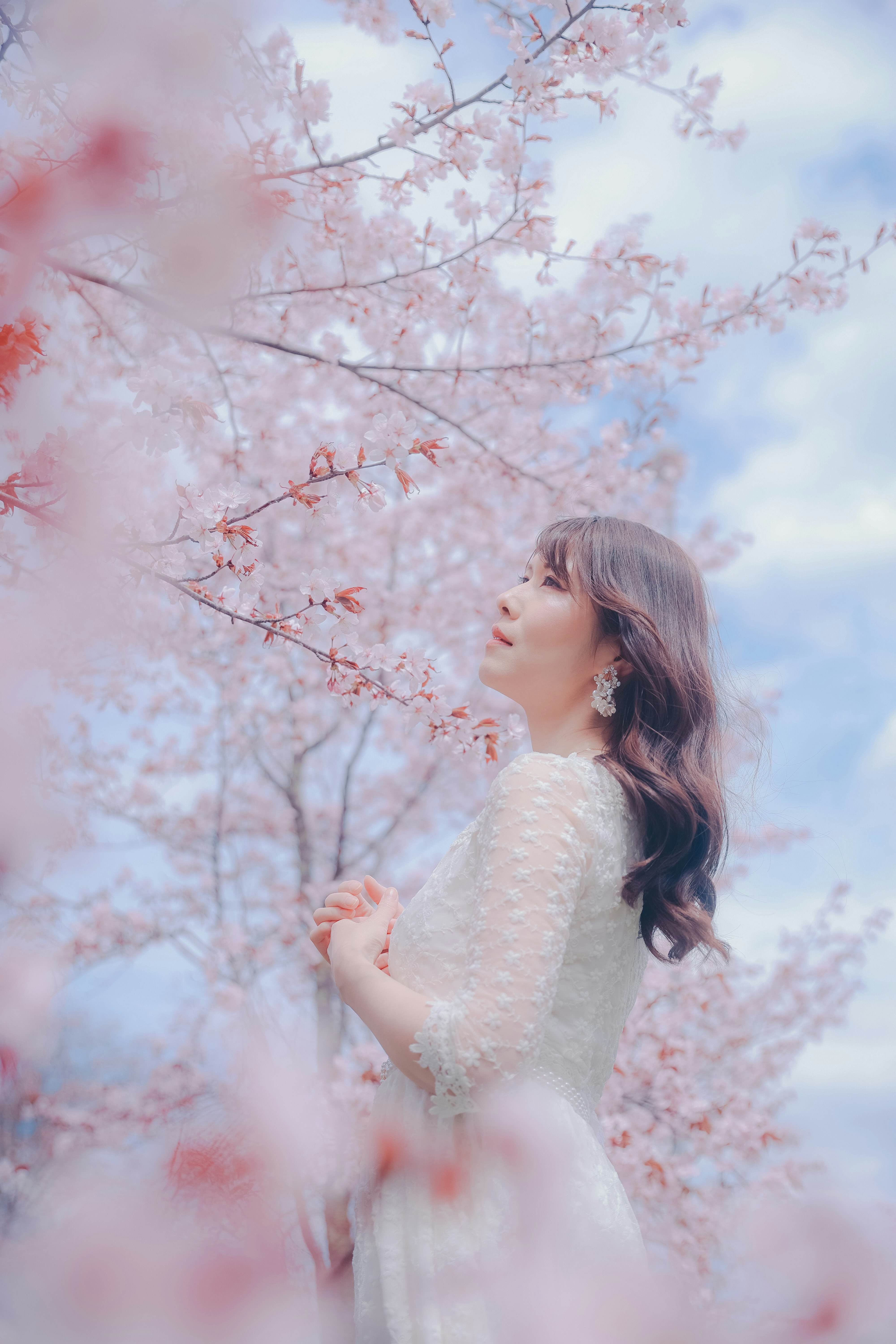 桜の花の間で微笑む女性