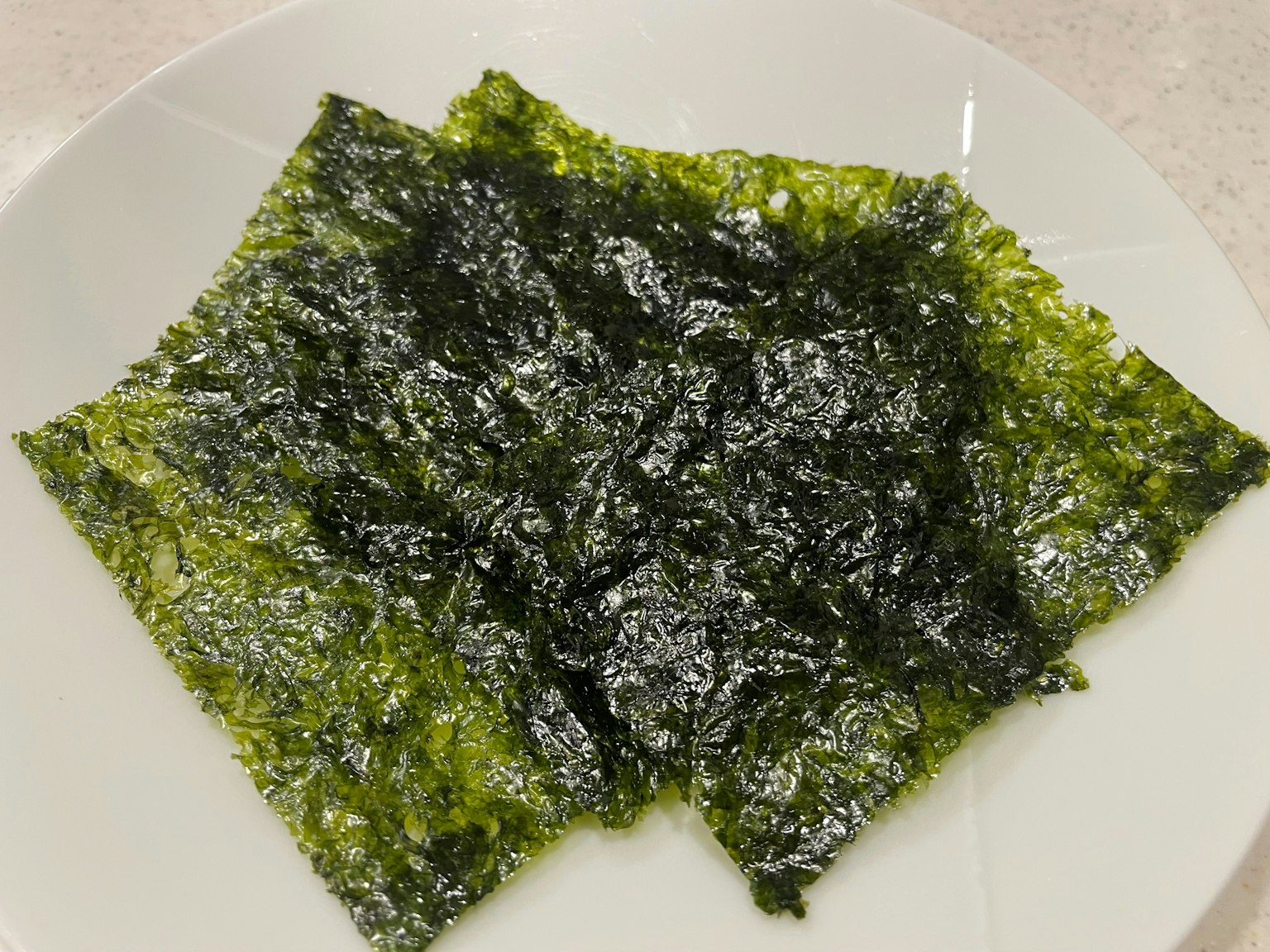 Algue verte placée sur une assiette blanche