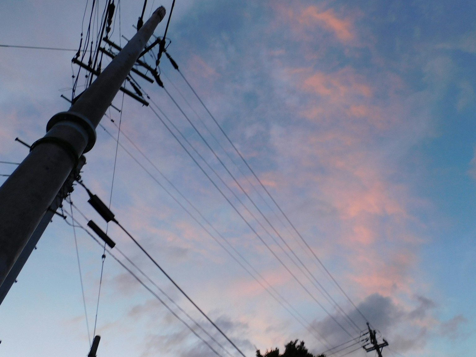 Foto di un palo della luce e linee elettriche contro un cielo al tramonto
