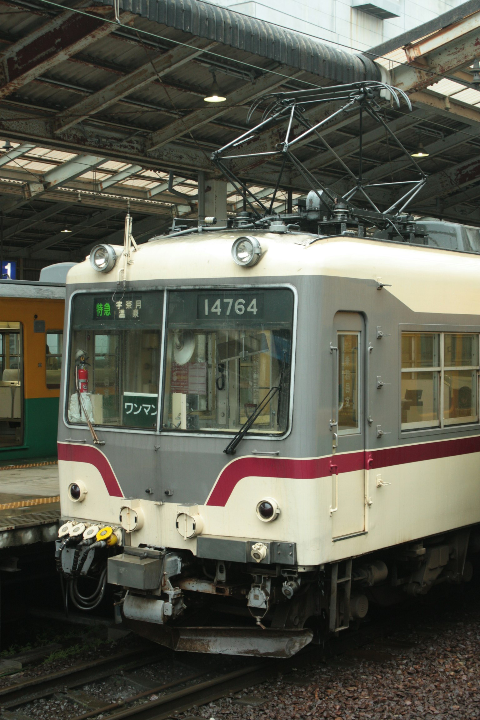 Un train blanc et rouge est garé sur le quai de la gare