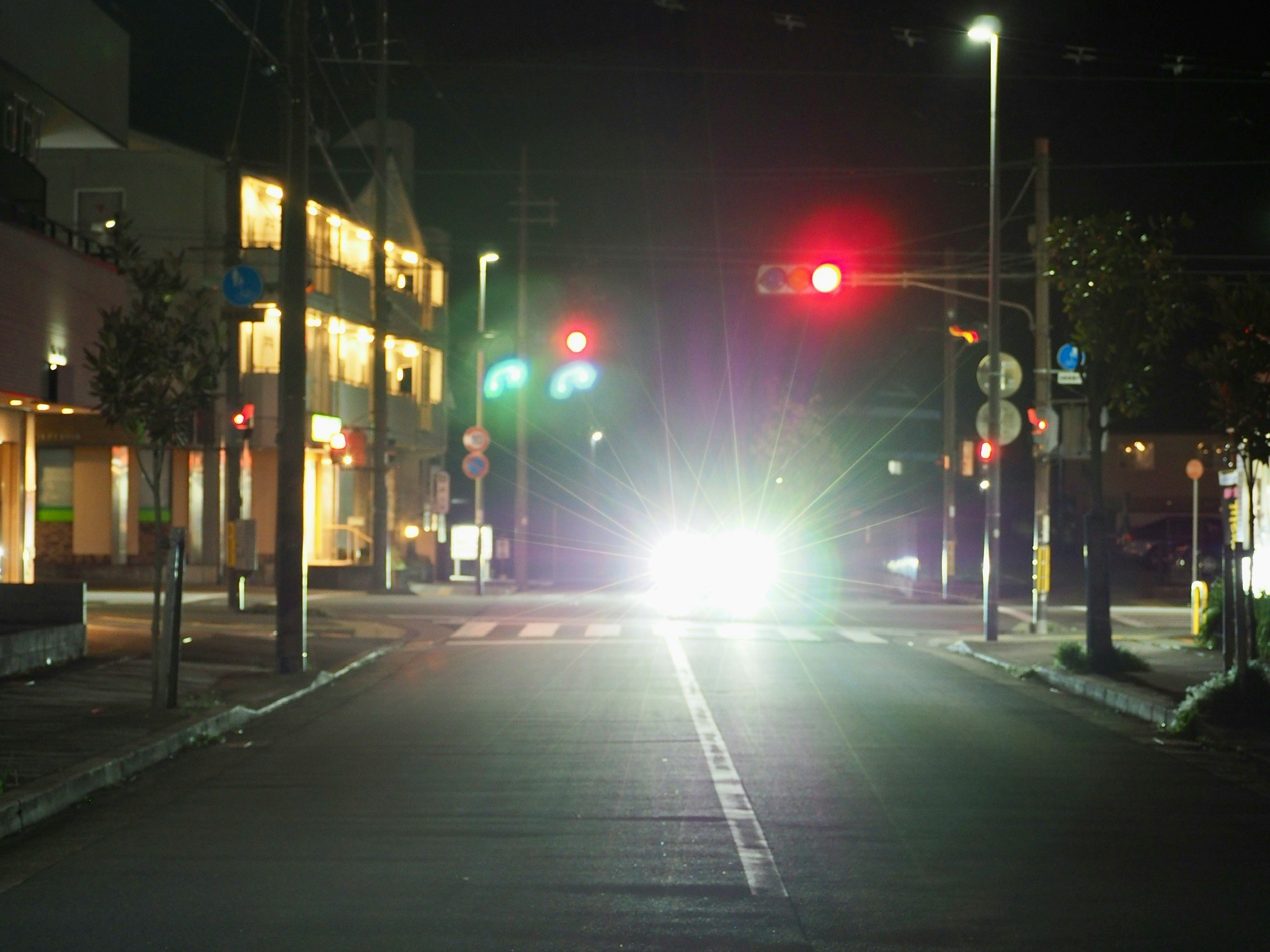 夜の街路灯が並ぶ交差点の道路風景