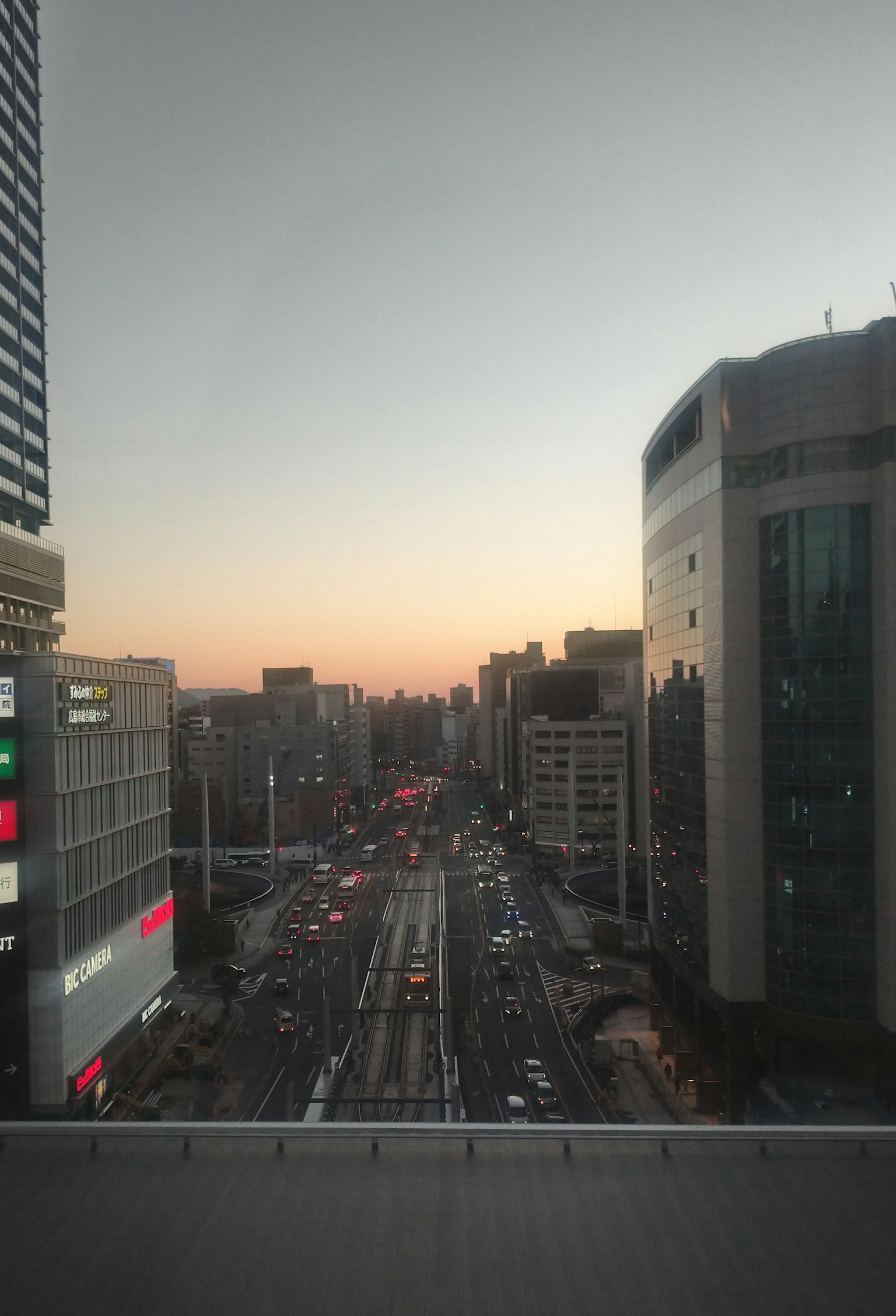 夕暮れ時の都市の風景 高層ビルと交通の流れが見える