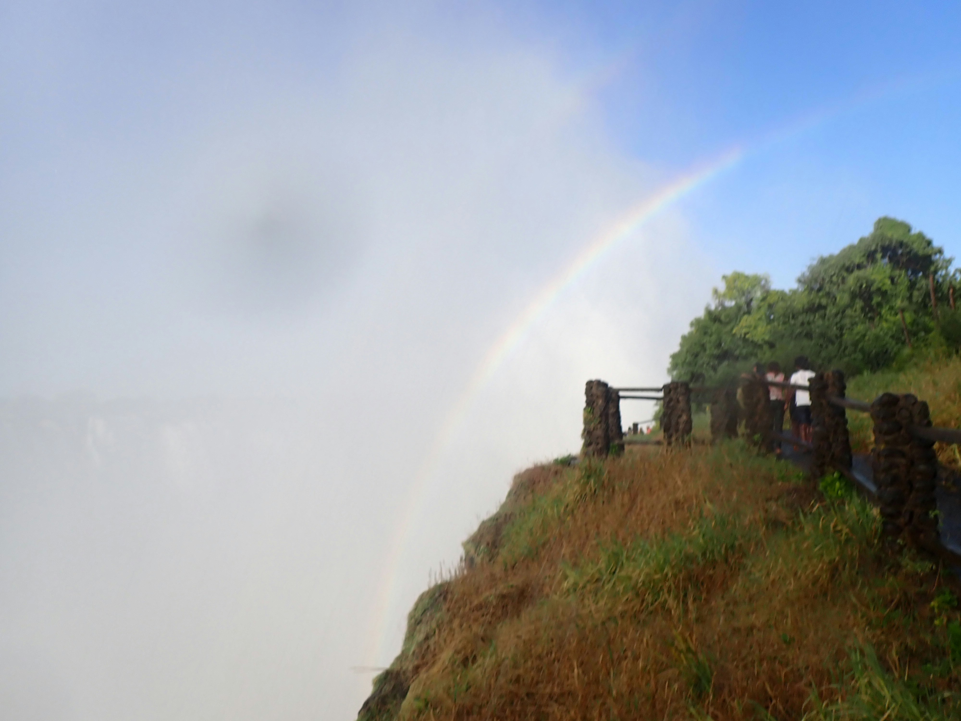 ruines en pierre sur une colline herbeuse avec un arc-en-ciel