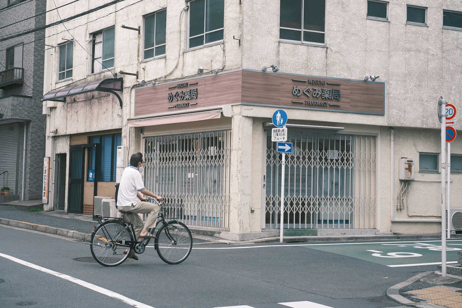 Un hombre montando una bicicleta cerca de una tienda cerrada en una esquina tranquila