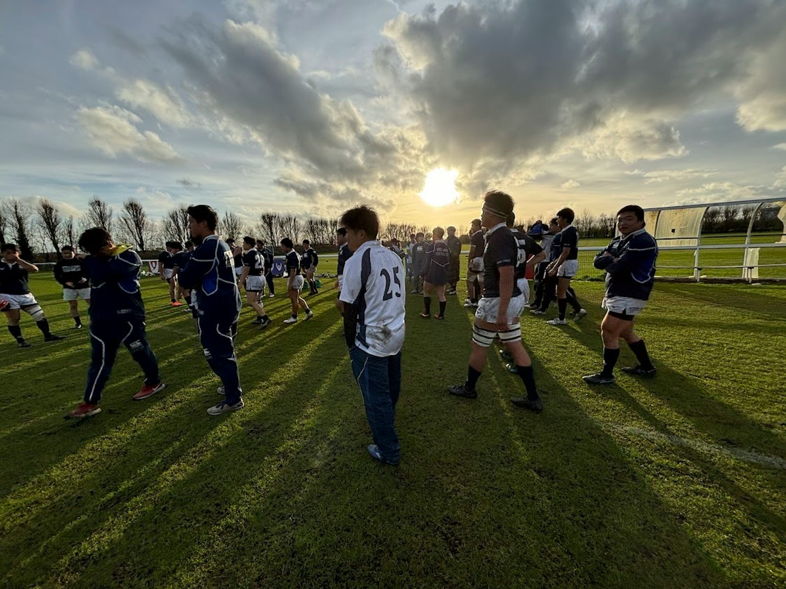 Jugadores de rugby practicando en el campo durante el atardecer