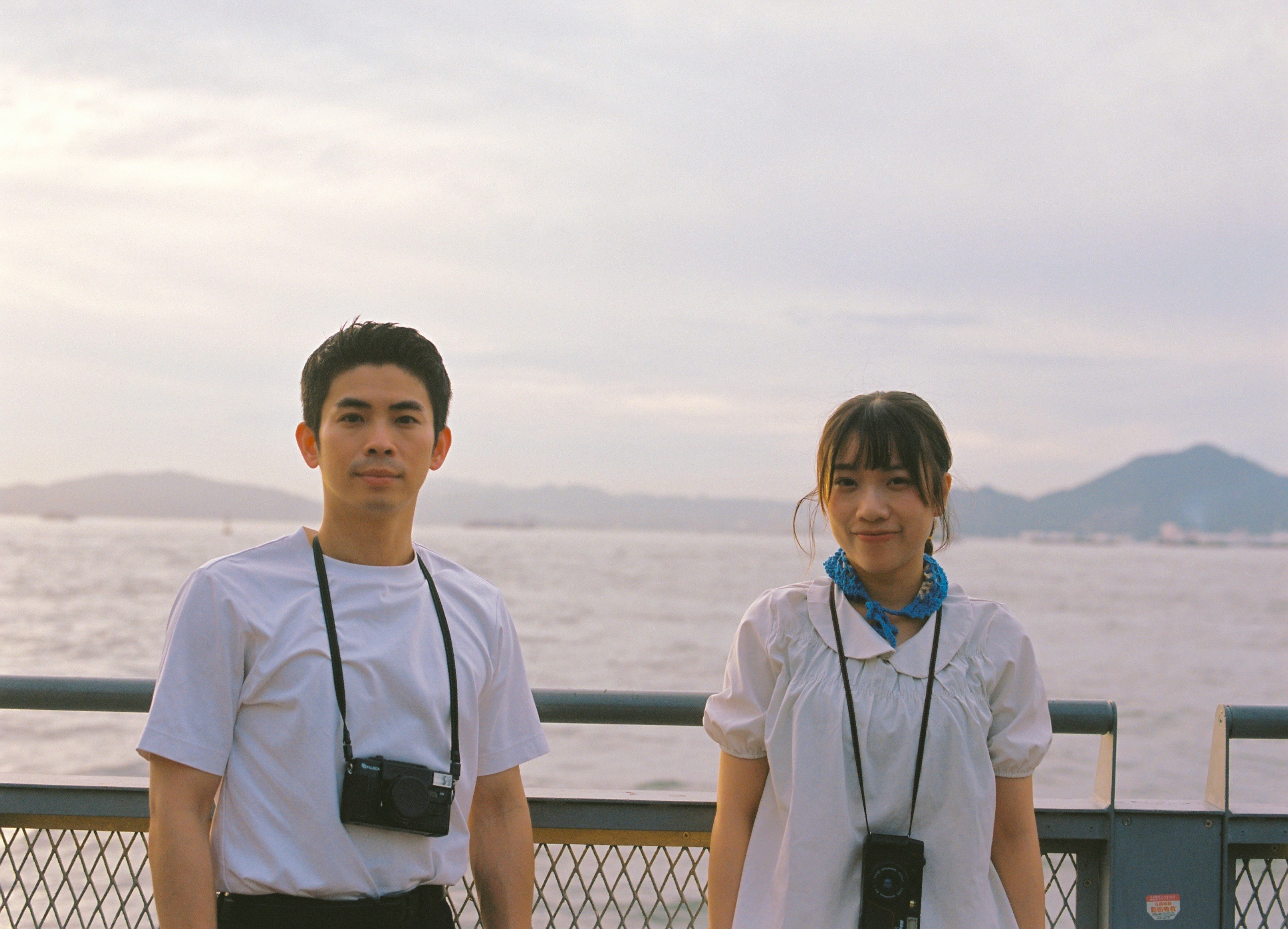 海辺の展望デッキで並ぶ2人のスタッフ