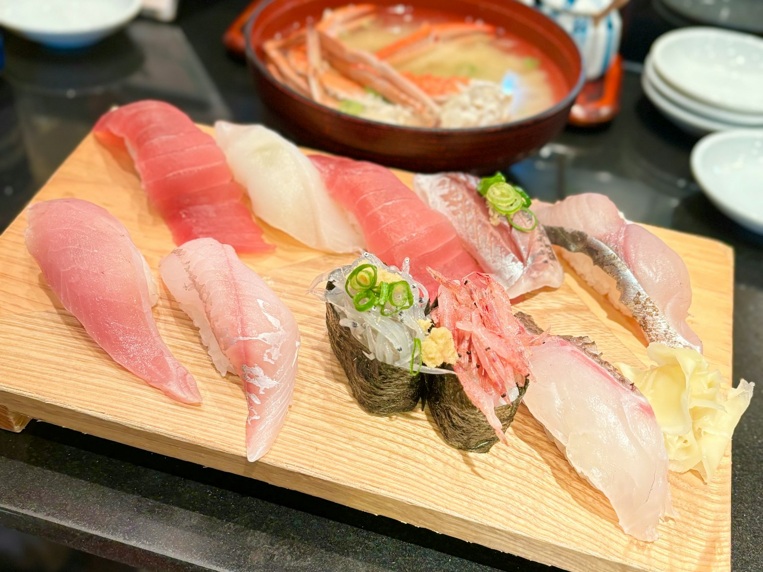 Một đĩa sushi tươi được bày trên một tấm ván gỗ