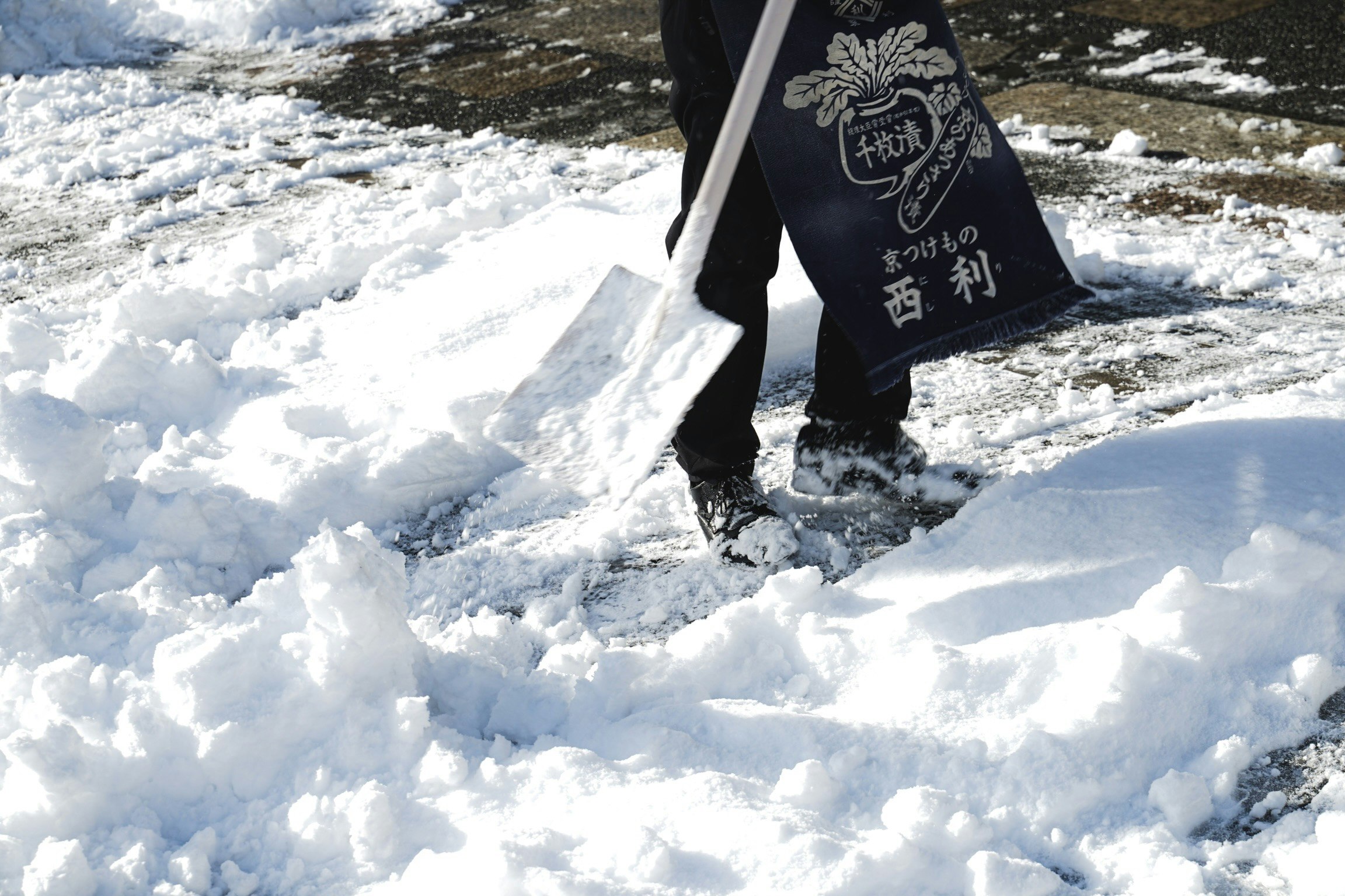 bottes et outils de déneigement sur un sol enneigé