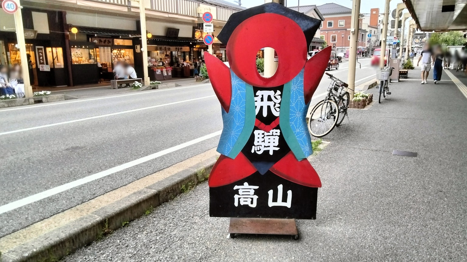 Señal colorida al borde de la carretera con un personaje en suéter azul y cuerpo rojo