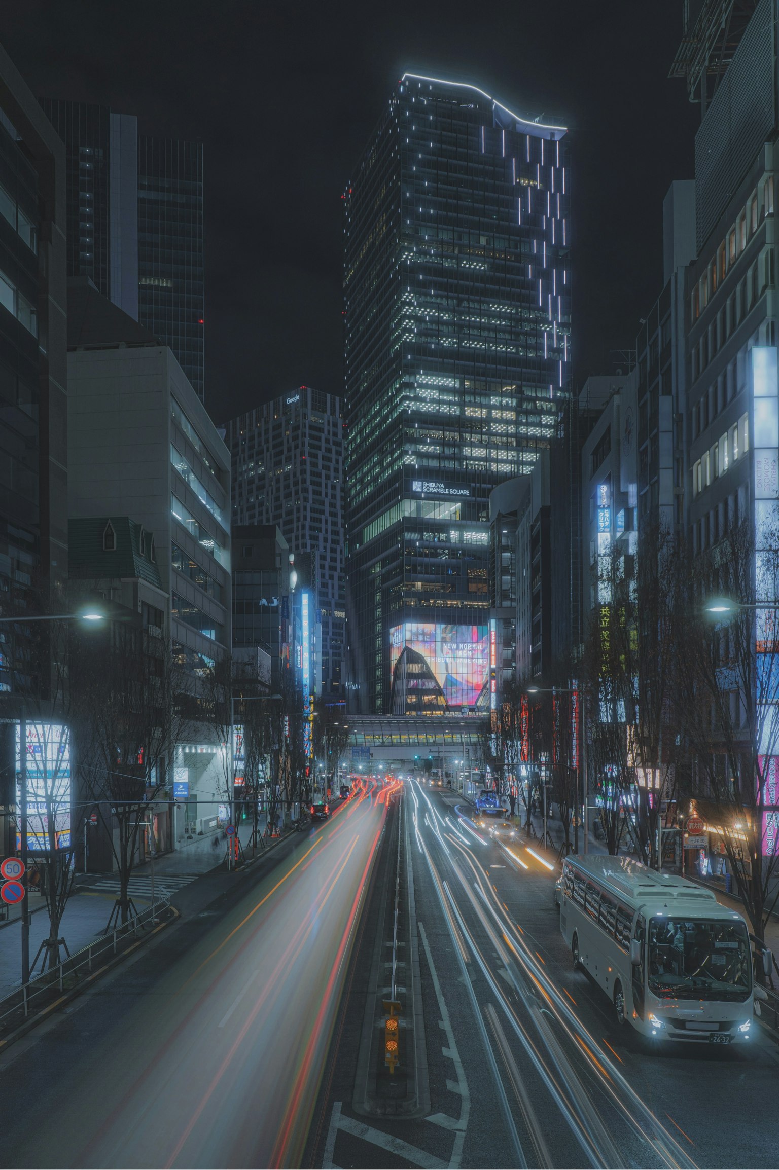 Nächtliche Stadtlandschaft mit Wolkenkratzern und fließendem Verkehr, beleuchtet von Neonlichtern