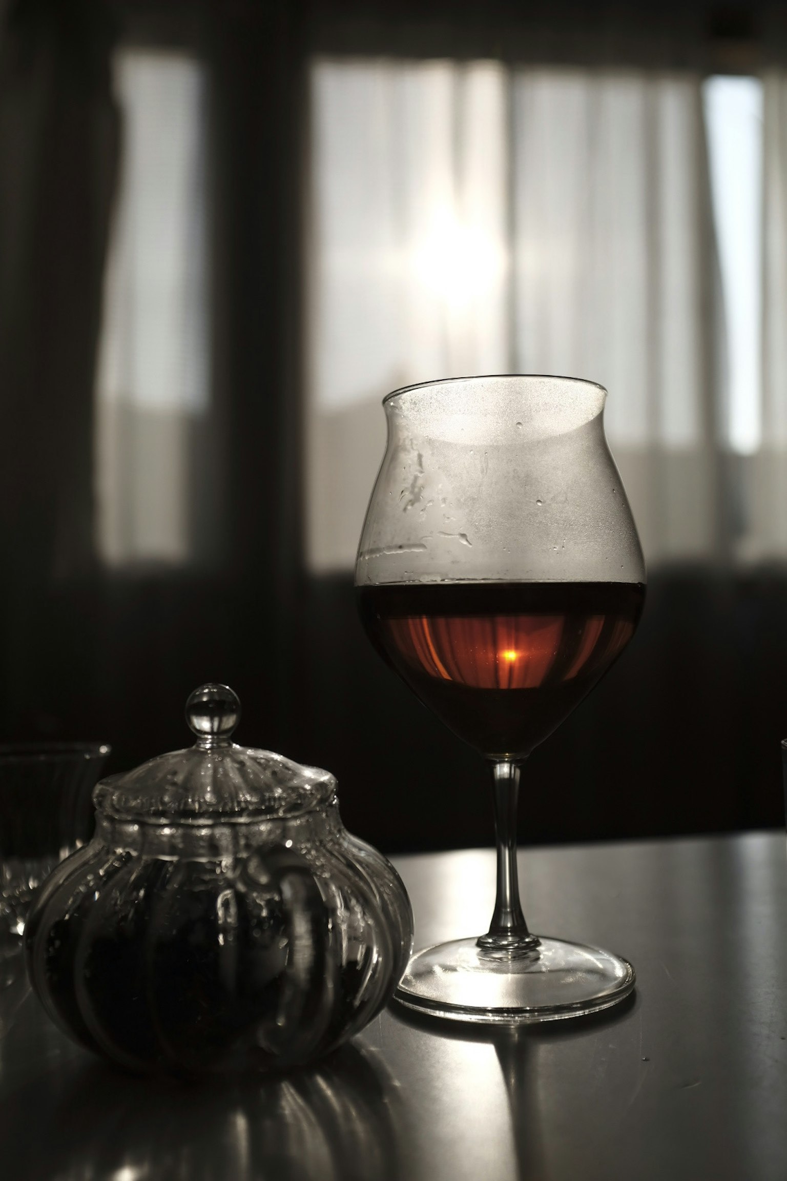 Silhouette eines bunten Cocktailglases und eines dekorativen Behälters auf einem Tisch