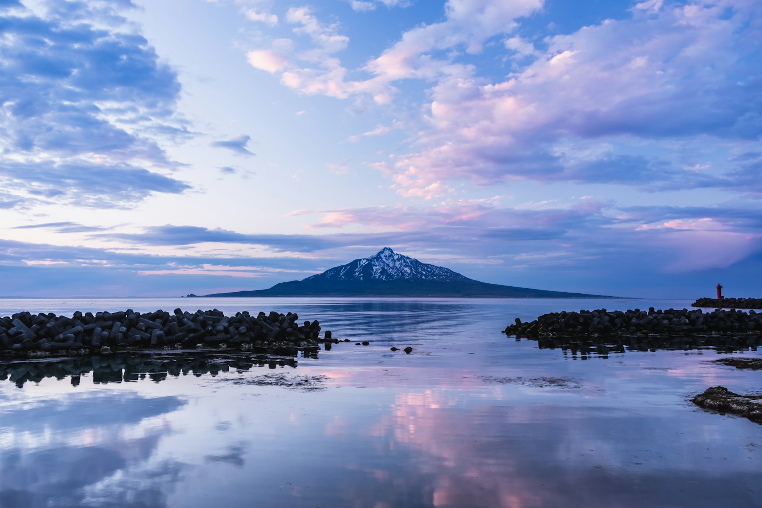 Gunung bersalju dengan laut tenang dan langit senja yang indah
