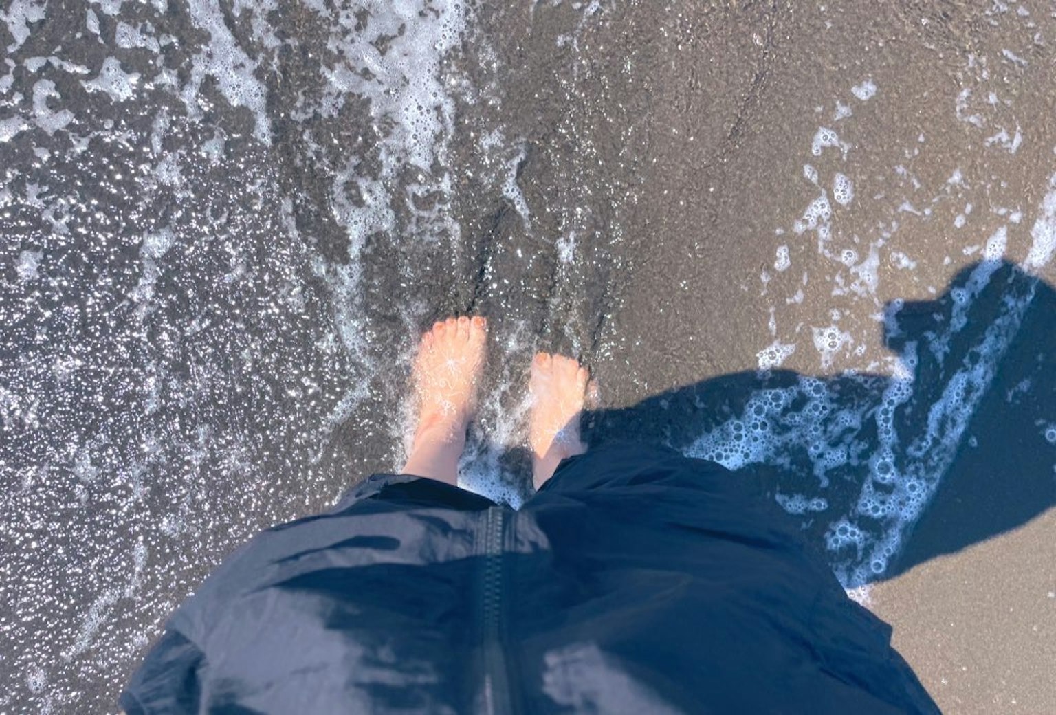 Piedi nell'acqua sulla riva con onde