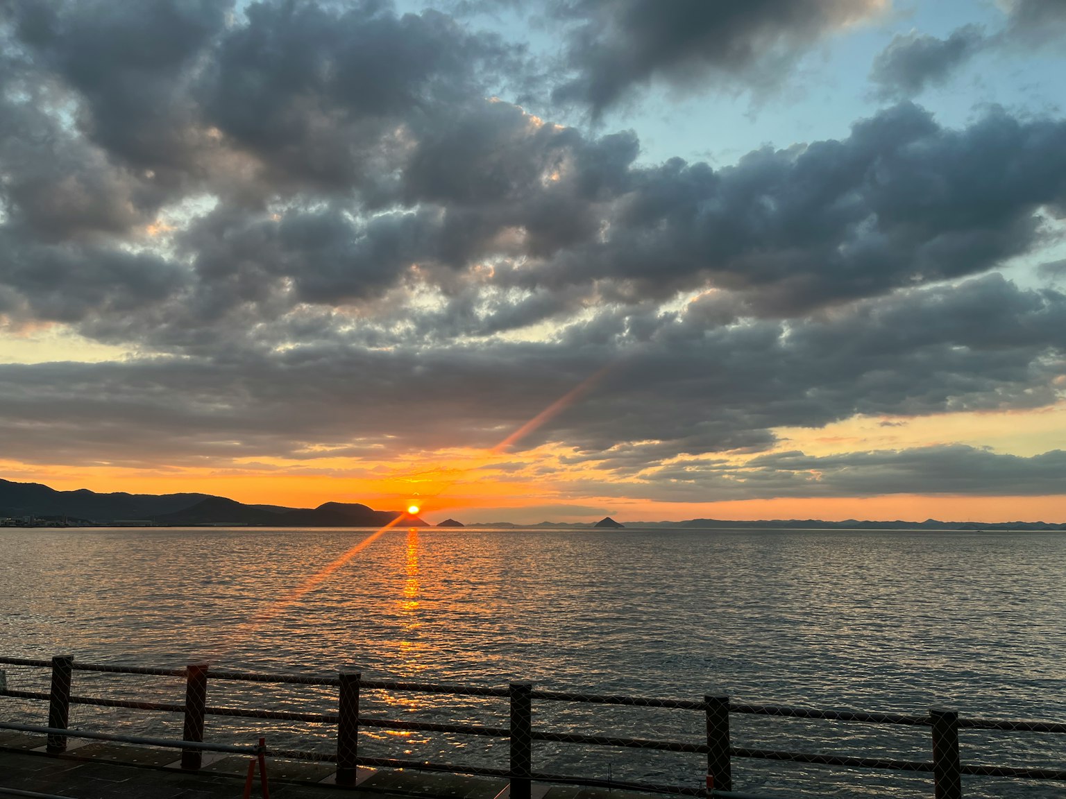 Tramonto sull'oceano con nuvole e un orizzonte lontano