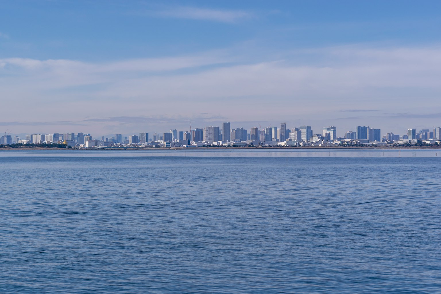 Vista di un mare blu con uno skyline di edifici moderni