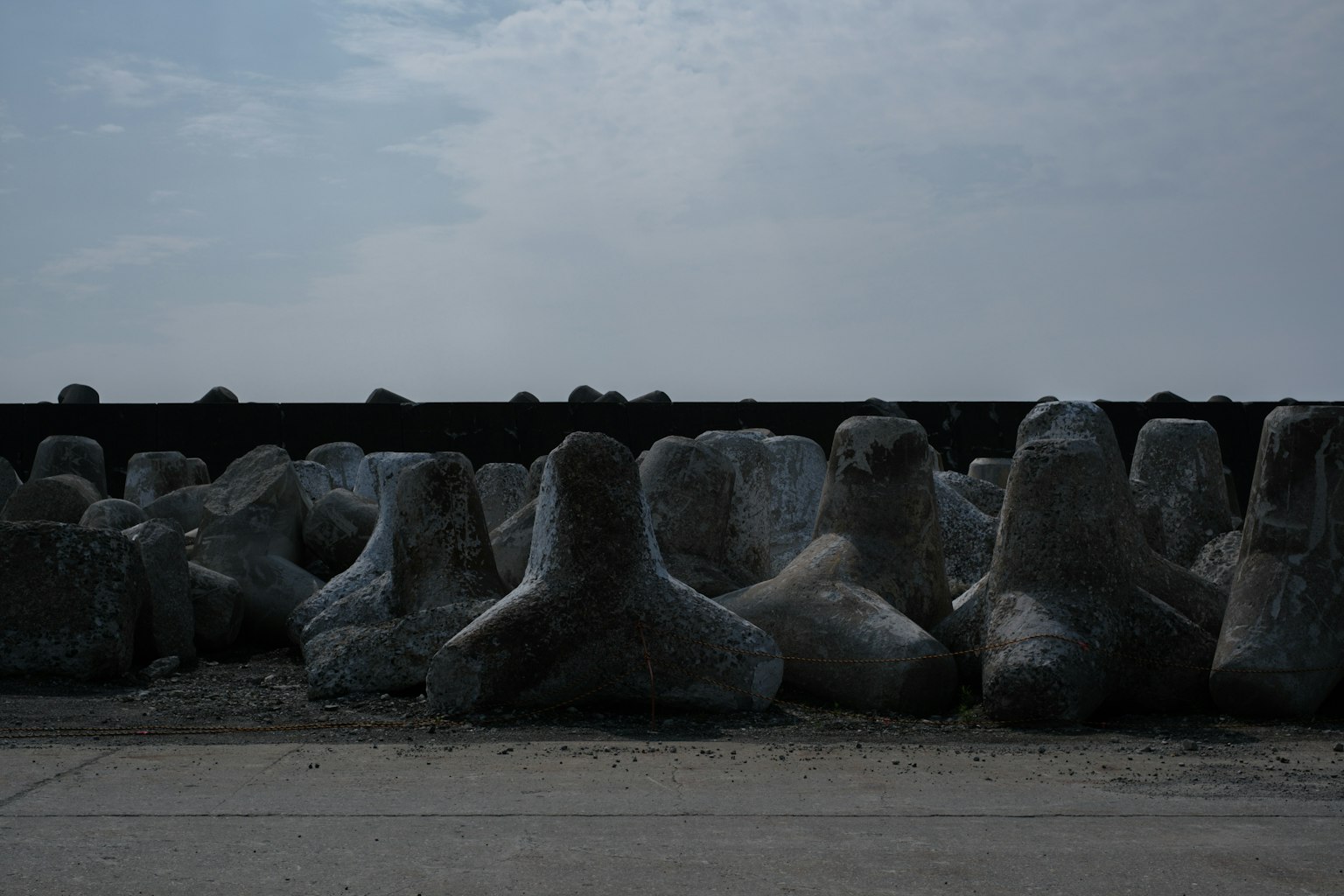 Bloques de rompeolas de concreto alineados en la costa