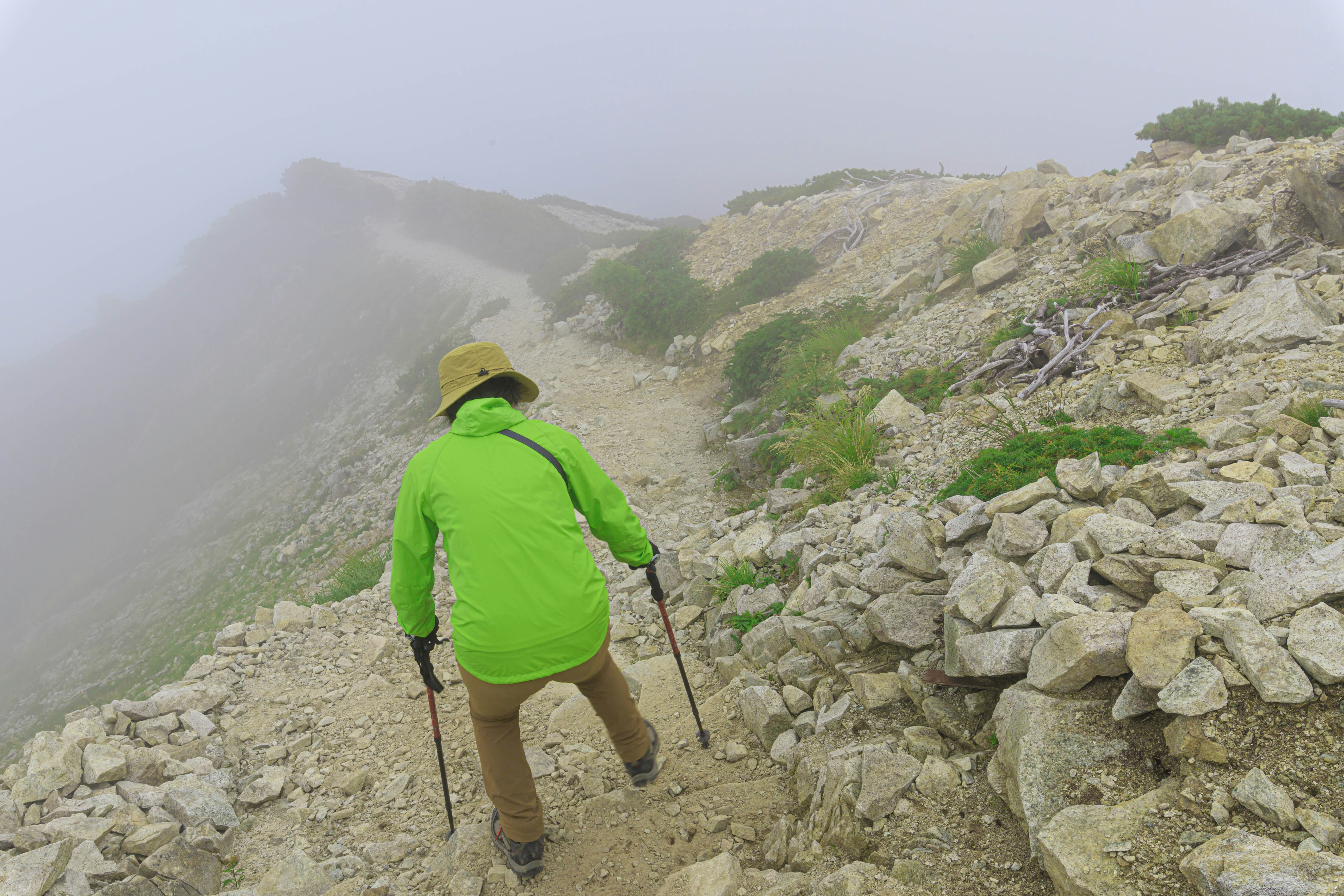 randonneur sur un sentier de montagne dans le brouillard