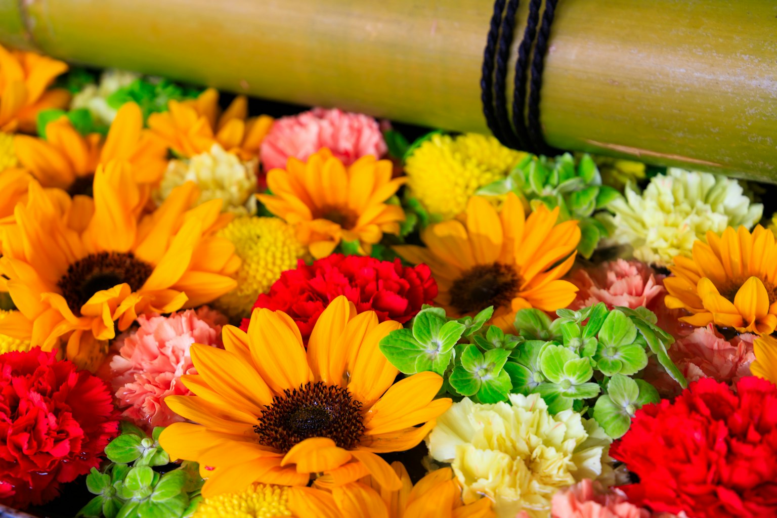 Un bellissimo arrangiamento di fiori colorati e un rotolo di bambù