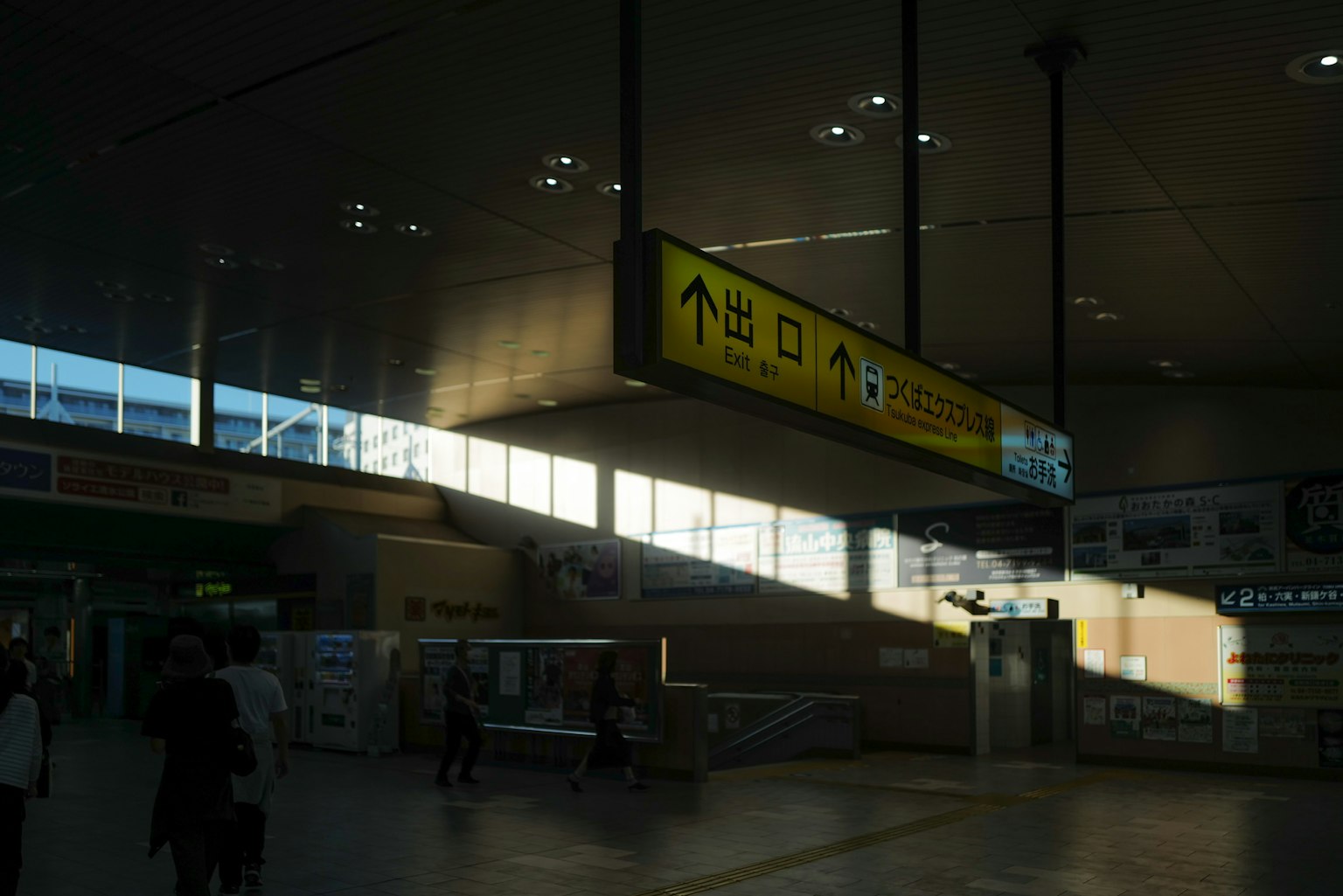 Interior of a train station with bright directional signs and people