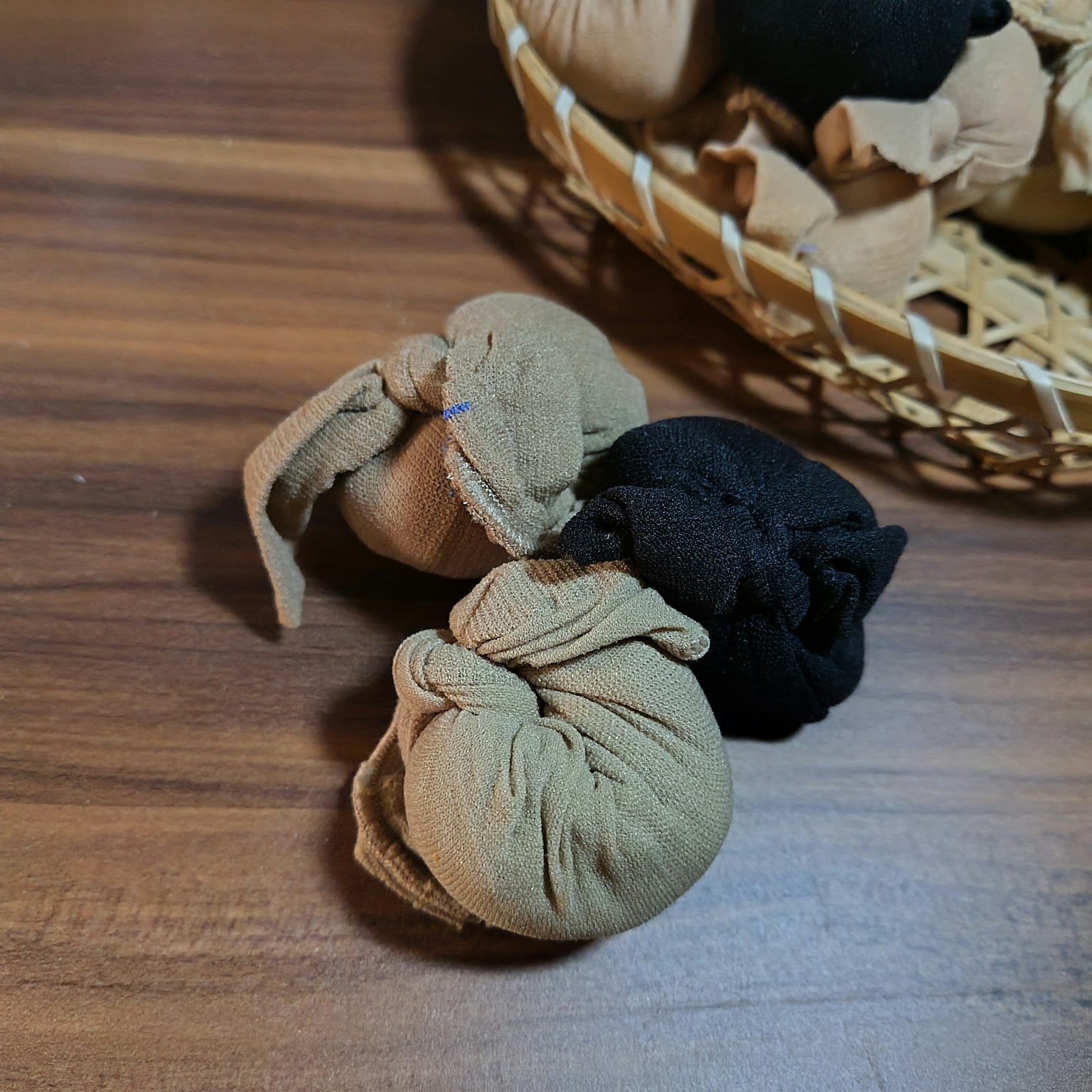 木桌上的米色和黑色布料小包