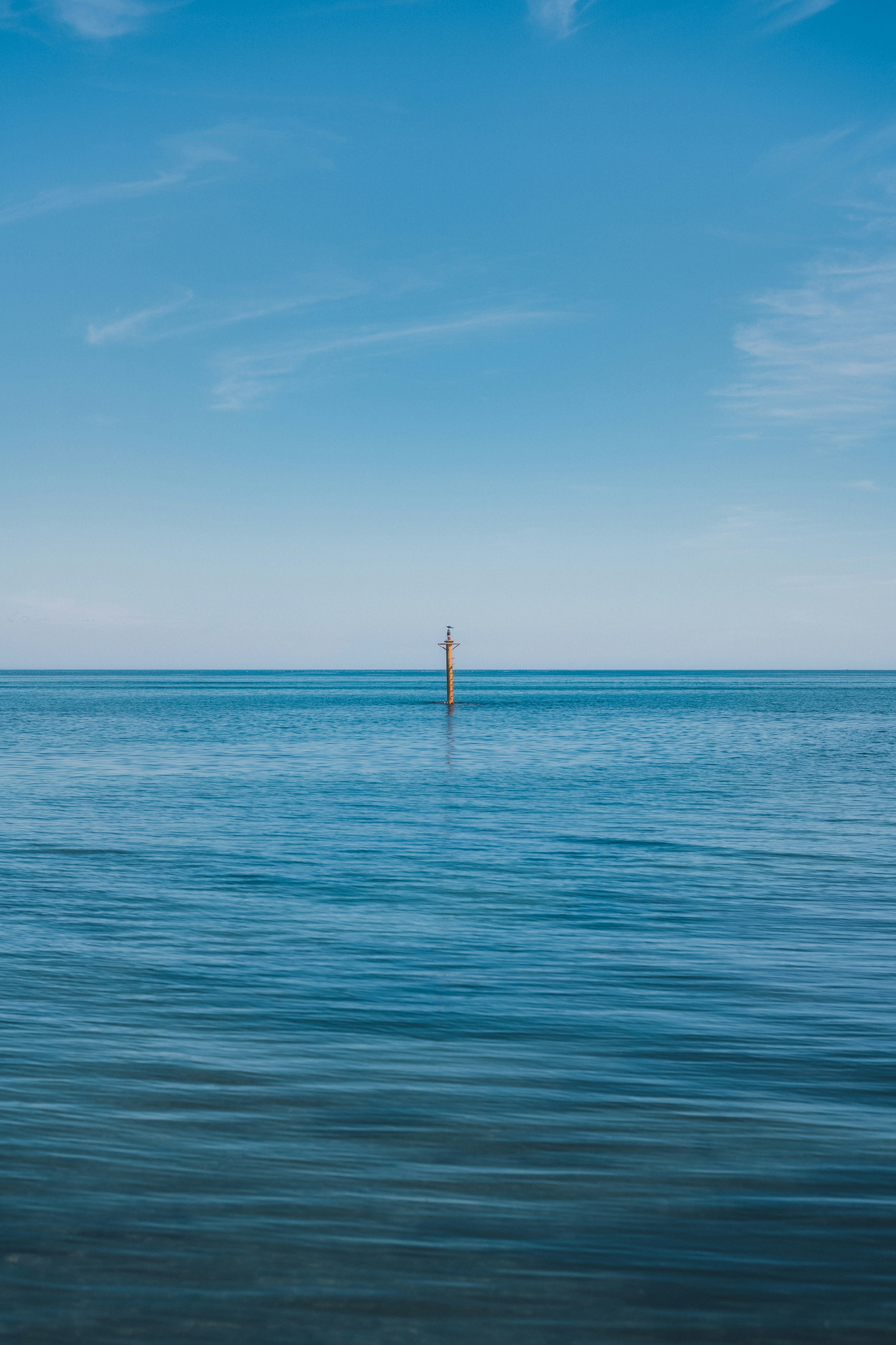水平線に伸びる海と沖の一本の杭