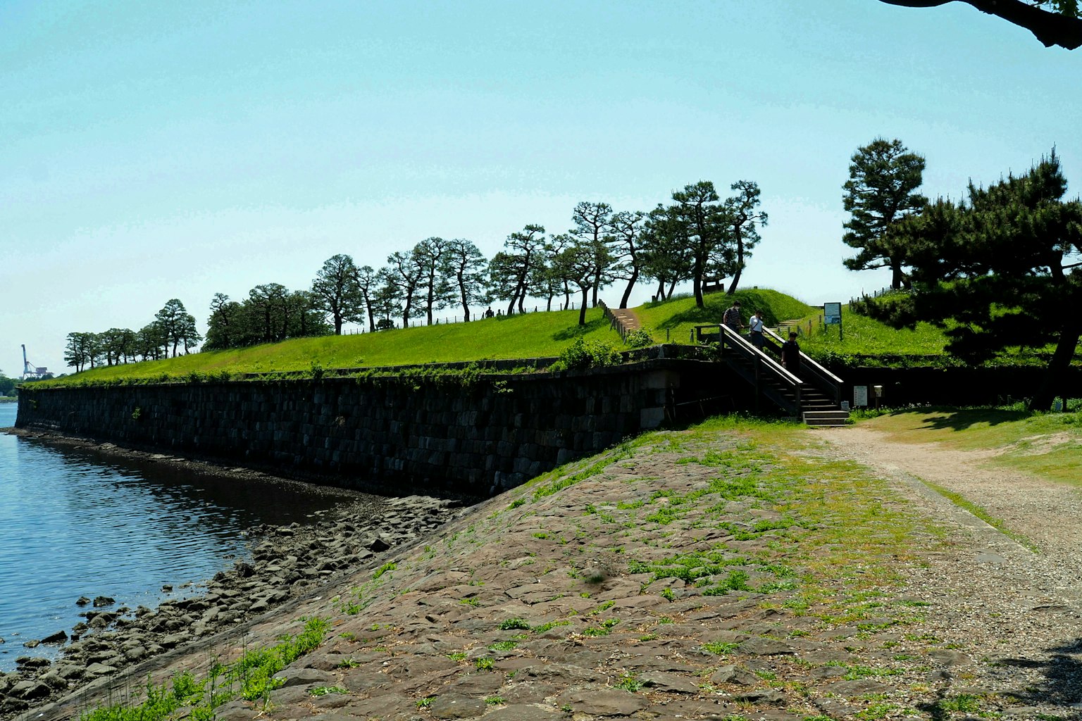 Malersicher Blick auf einen grünen Park entlang der Küste mit einem Steinwall