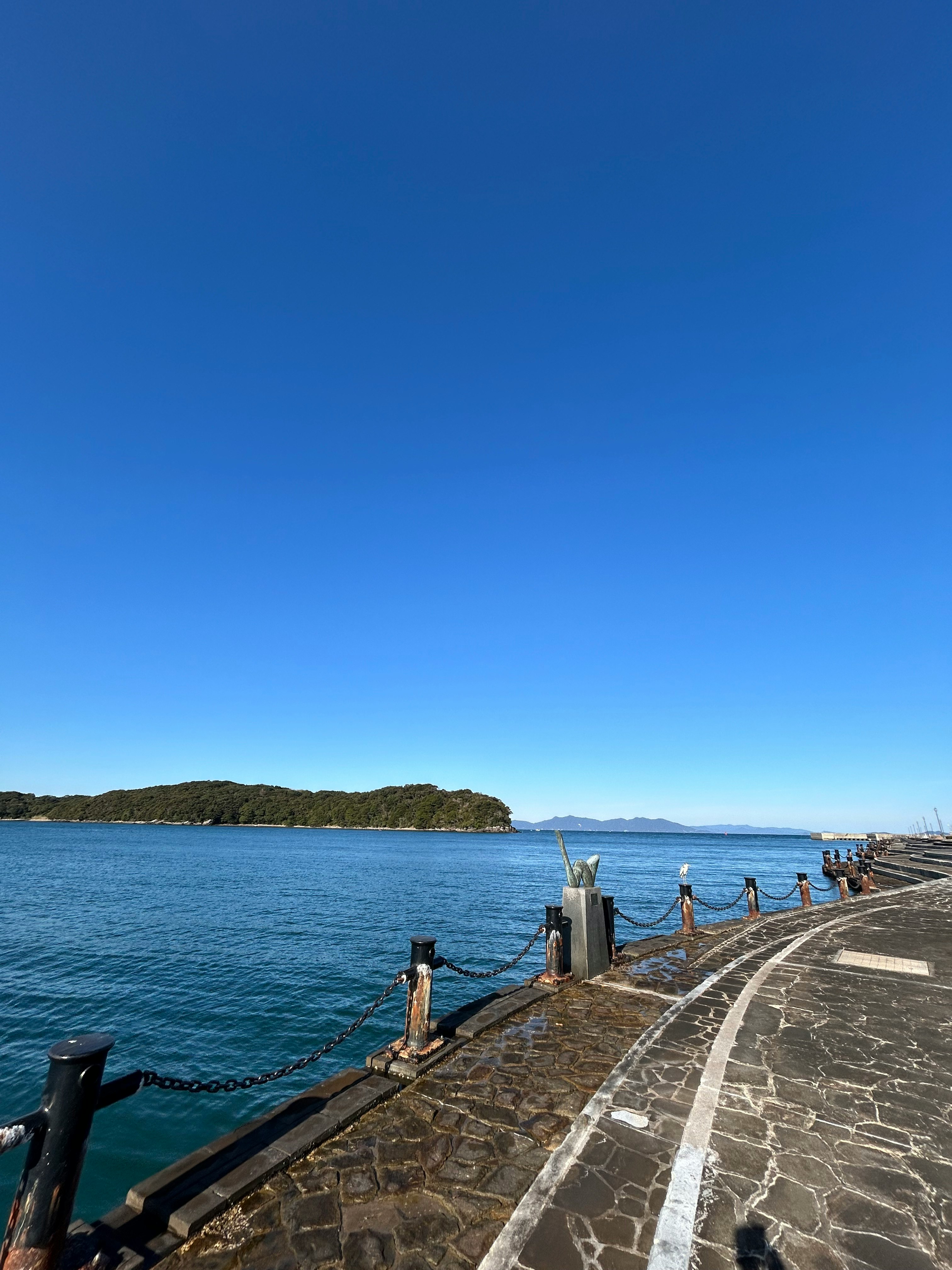 海沿いの遊歩道と穏やかな入江の景色