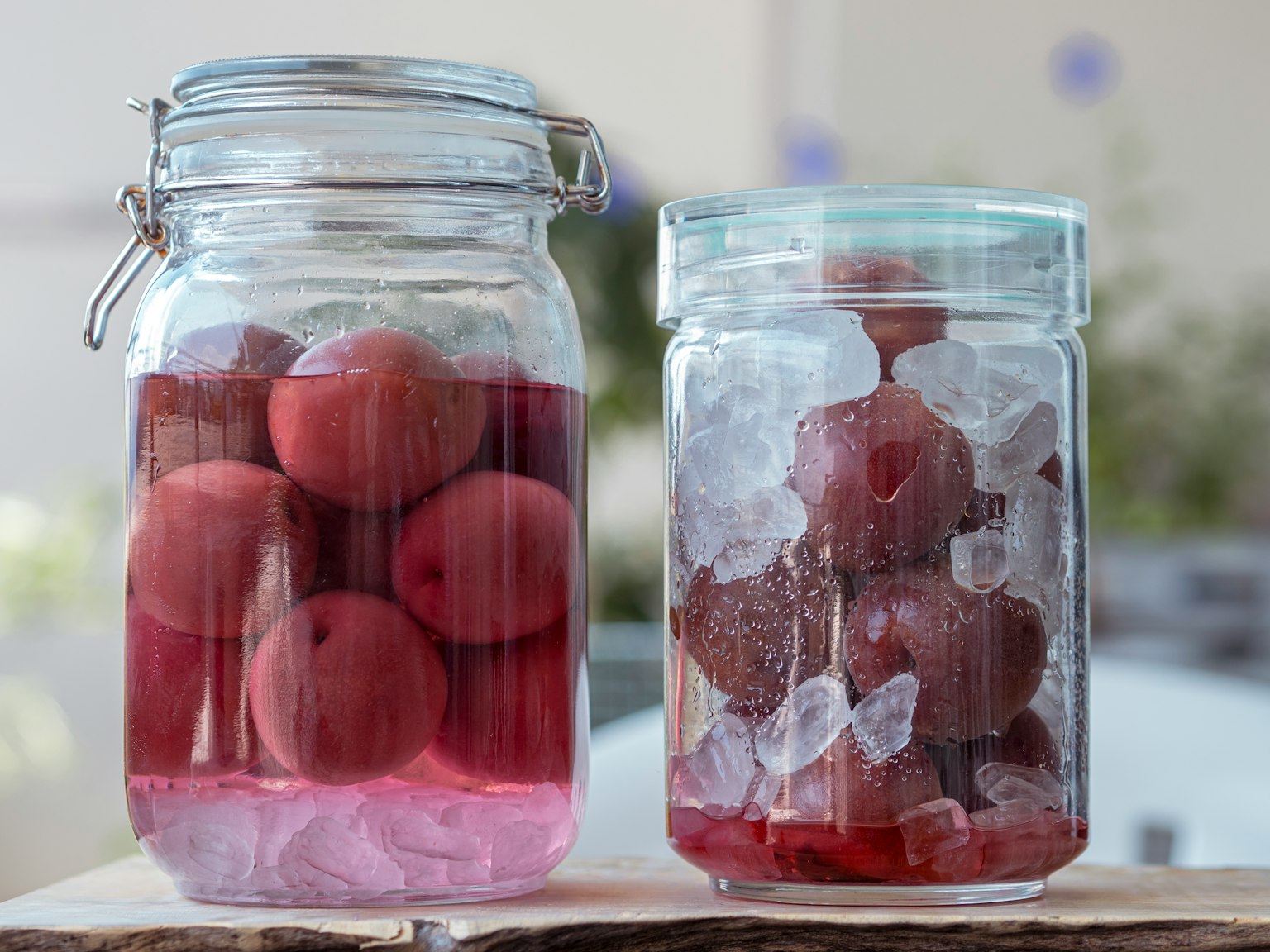 Due barattoli di vetro con frutti rossi uno riempito di liquido
