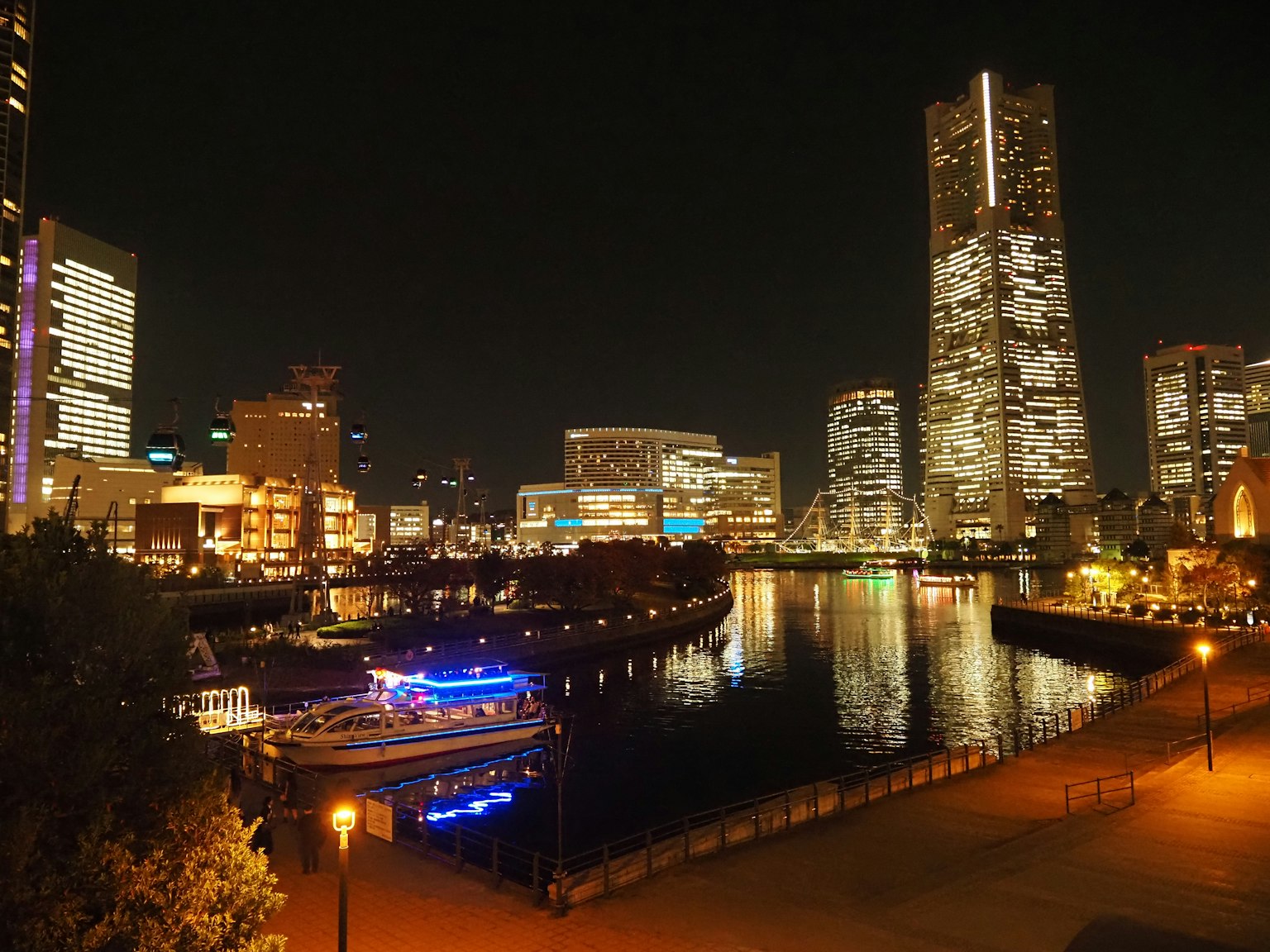 Vista nocturna de Yokohama con edificios iluminados y río