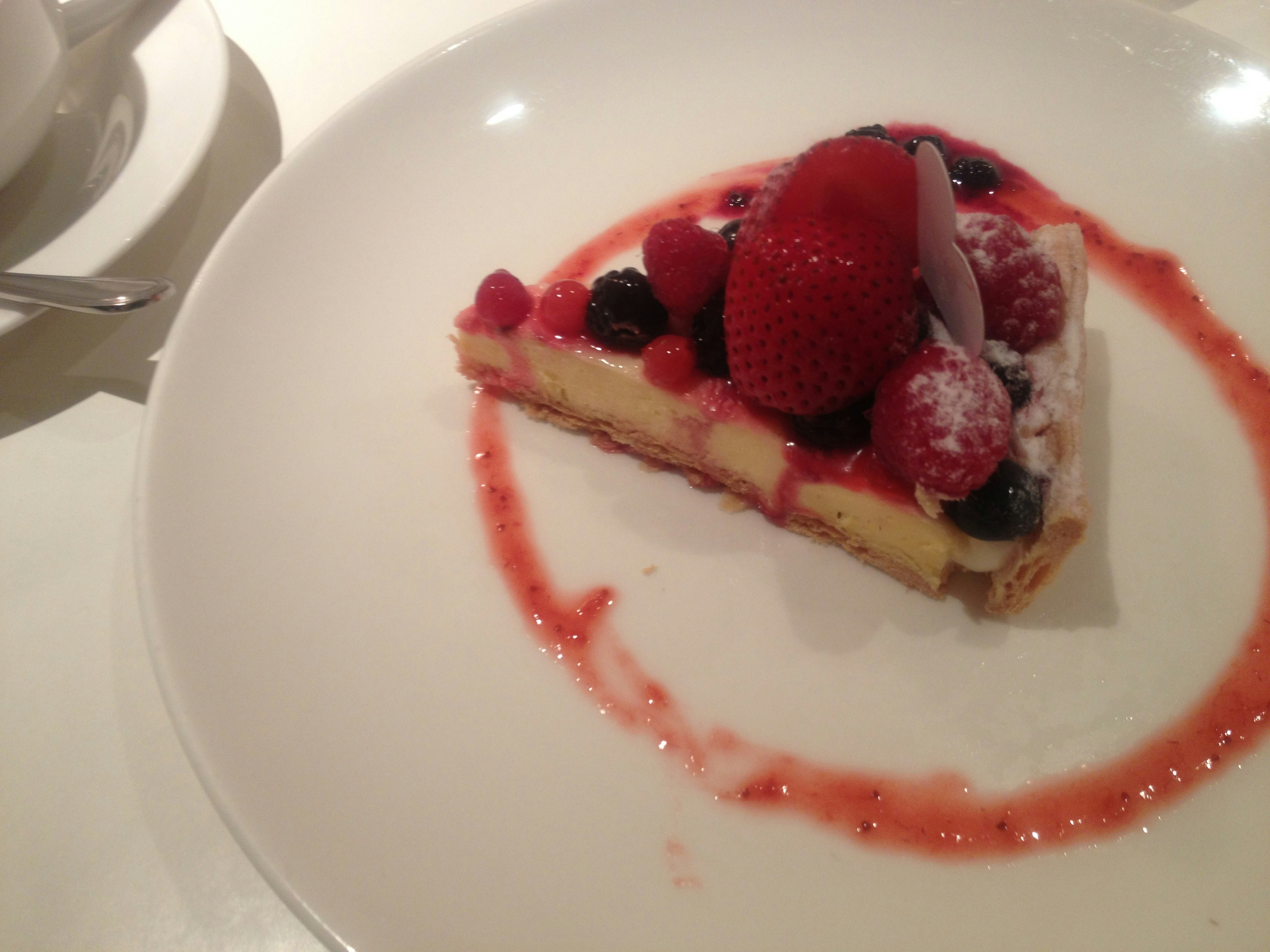 tart buah beri di piring putih dengan saus