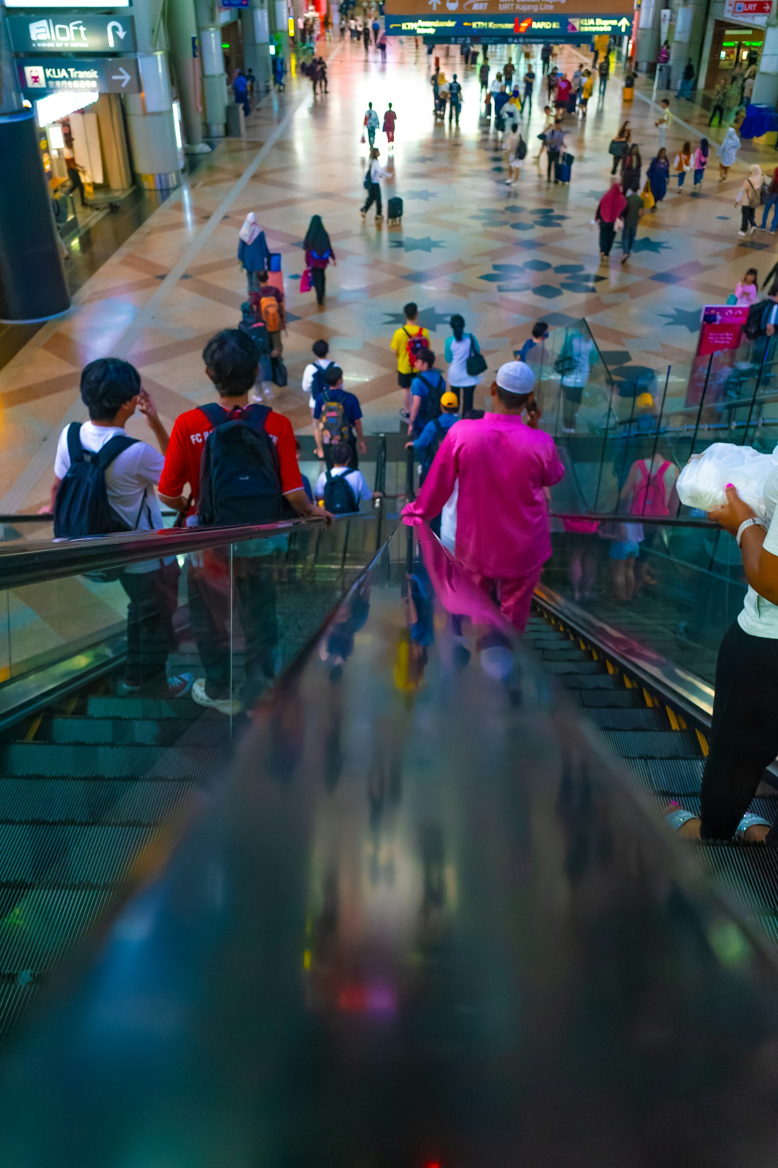 Una scena vivace di un centro commerciale vista dall'alto di una scala mobile con molte persone in movimento