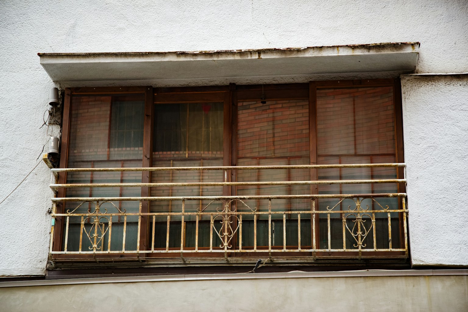 Vecchio balcone in legno con un edificio a muro bianco