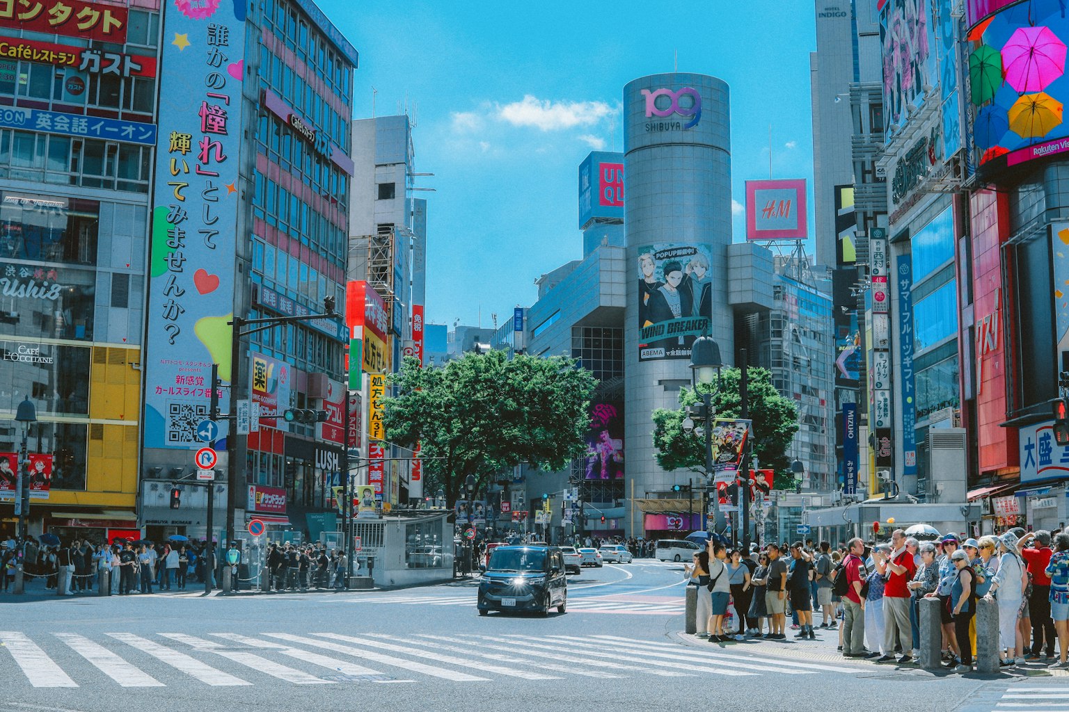 Belebte Shibuya-Kreuzung mit Fußgängern, die auf das Überqueren warten und bunten Gebäuden