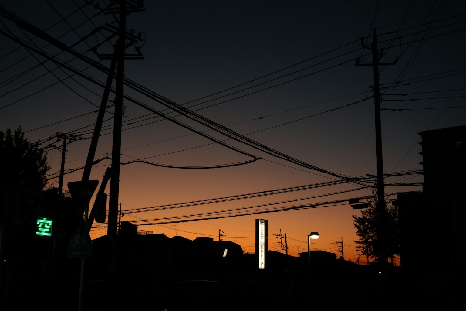 Silhouette of a city at dusk with power lines