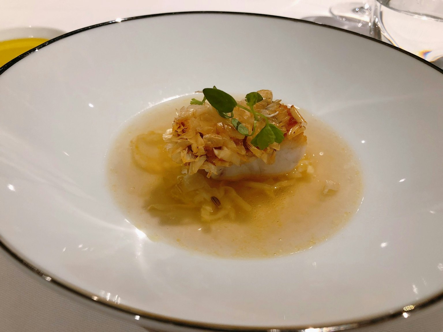 Piatto elegante con piatto di pesce guarnito con erbe