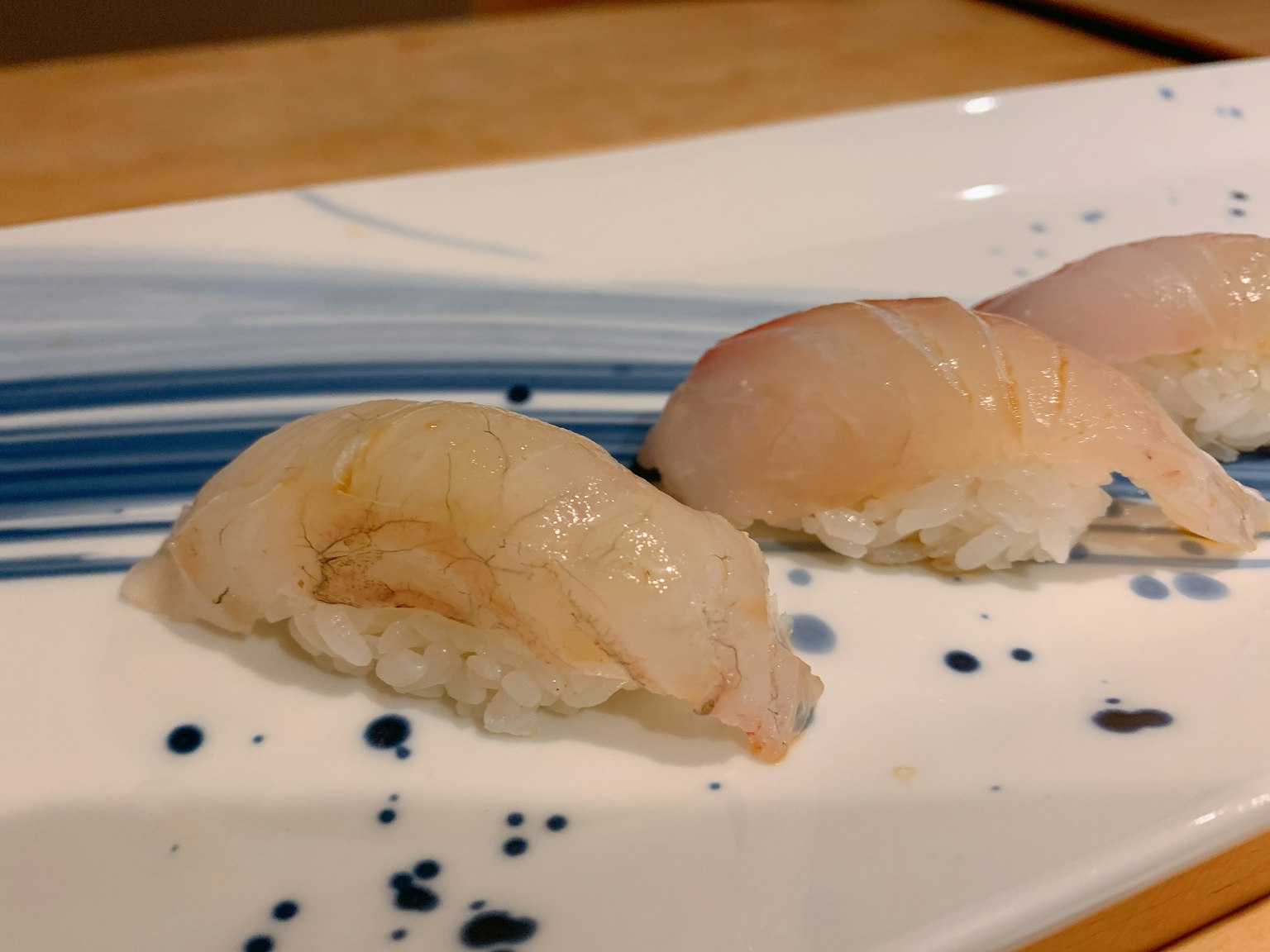 Three pieces of sushi on a blue striped plate