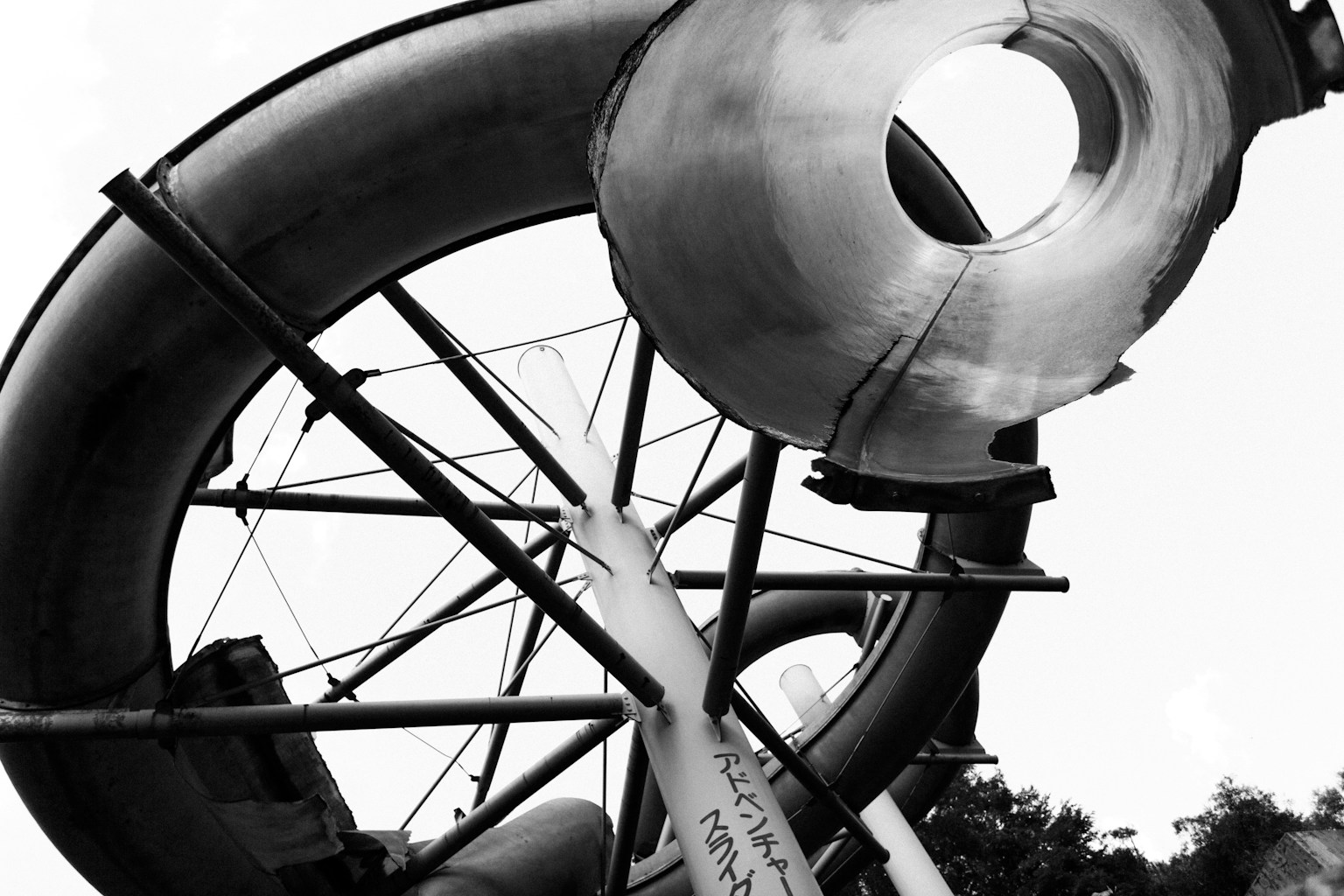 Photo en noir et blanc d'une structure de toboggan avec un grand tube et un cadre de support