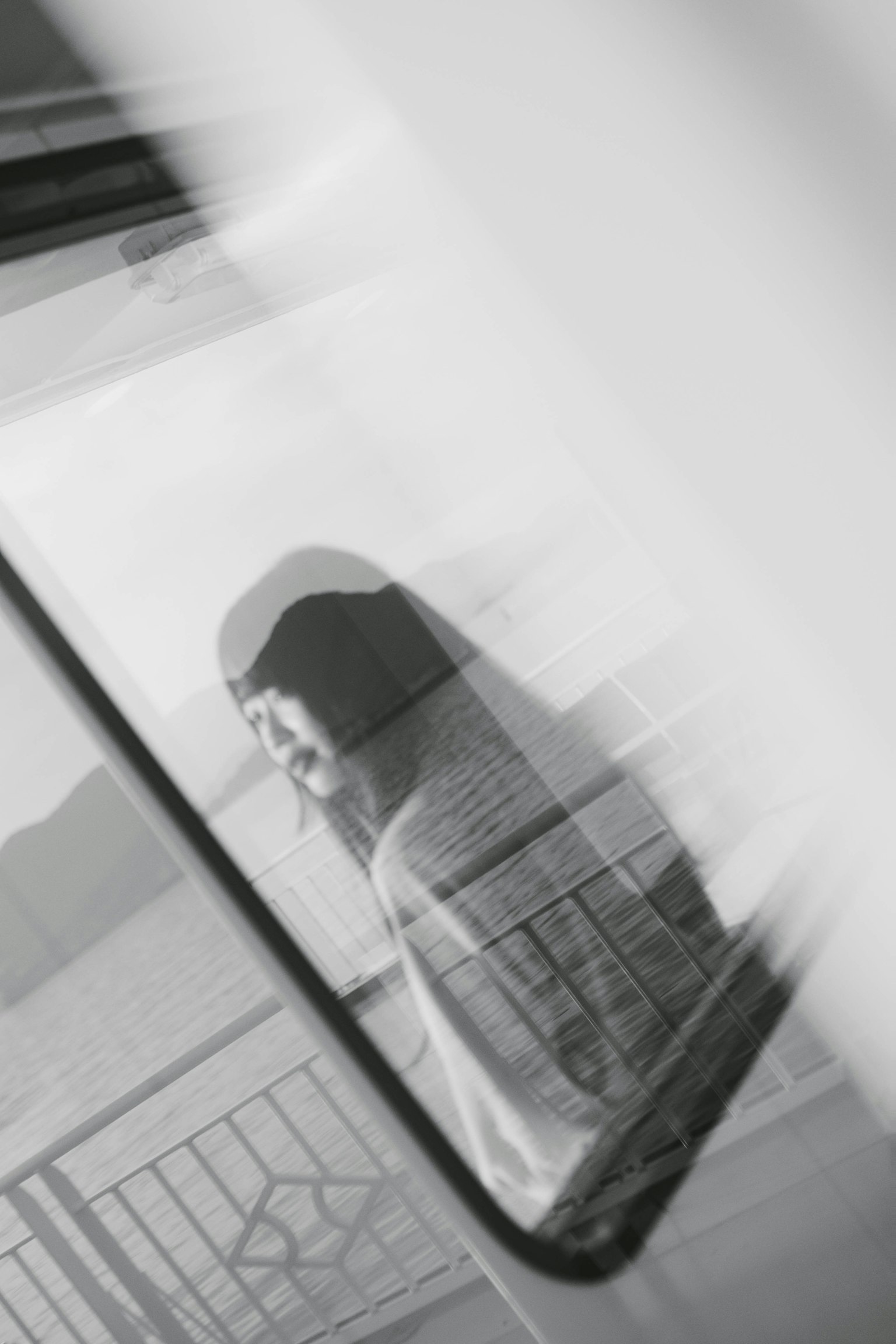 Eine Frau, die aus einem Fenster in einem Schwarz-Weiß-Bild schaut