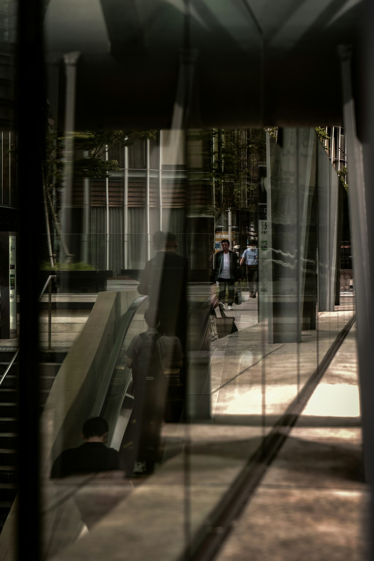 Architecture moderne reflétée dans le verre avec des personnes marchant