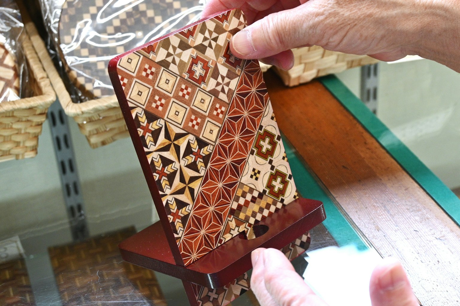 Pezzo decorativo in legno con motivi intricati tenuto in mano che mostra bellissimi disegni