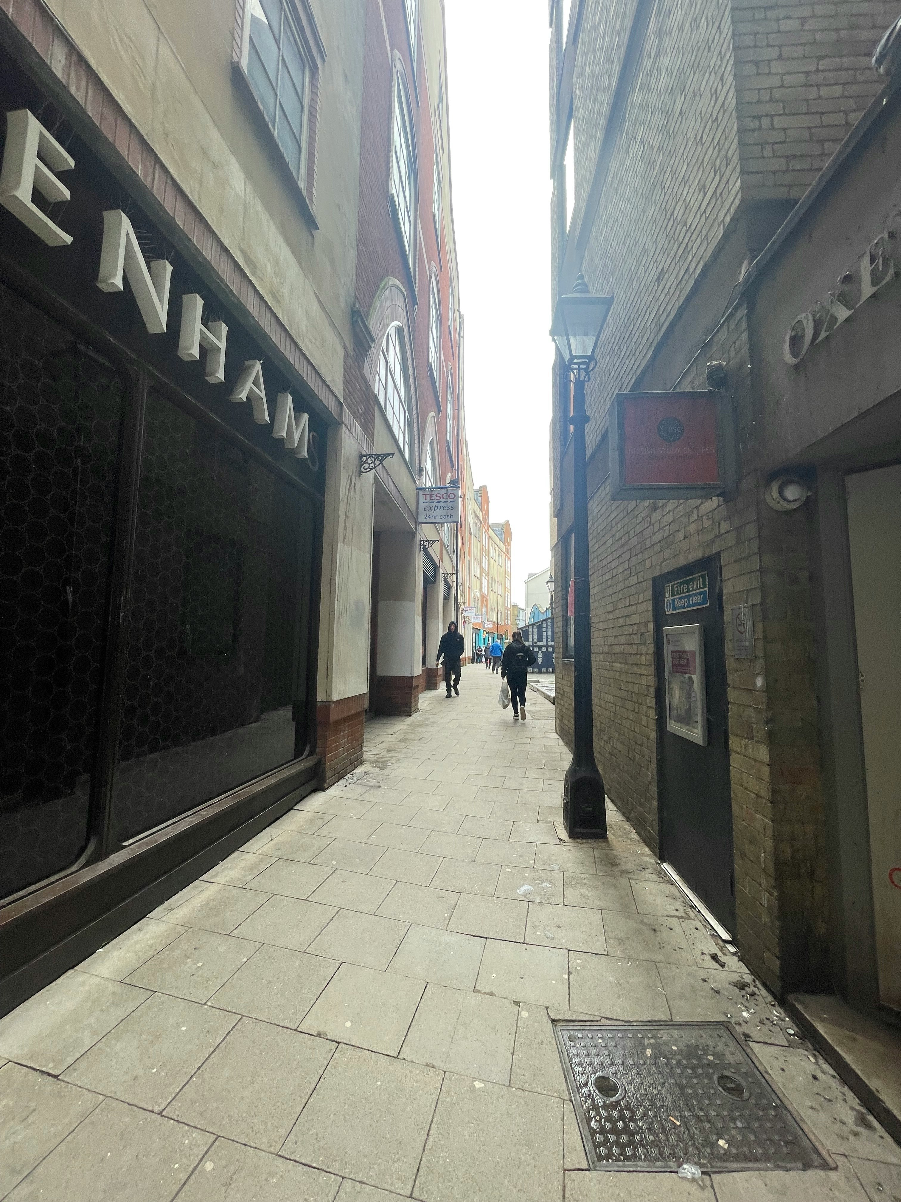 ロンドンの路地に並ぶ石造りの建物と看板