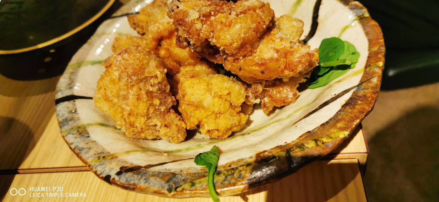 一盘酥脆炸鸡块装饰着绿色蔬菜