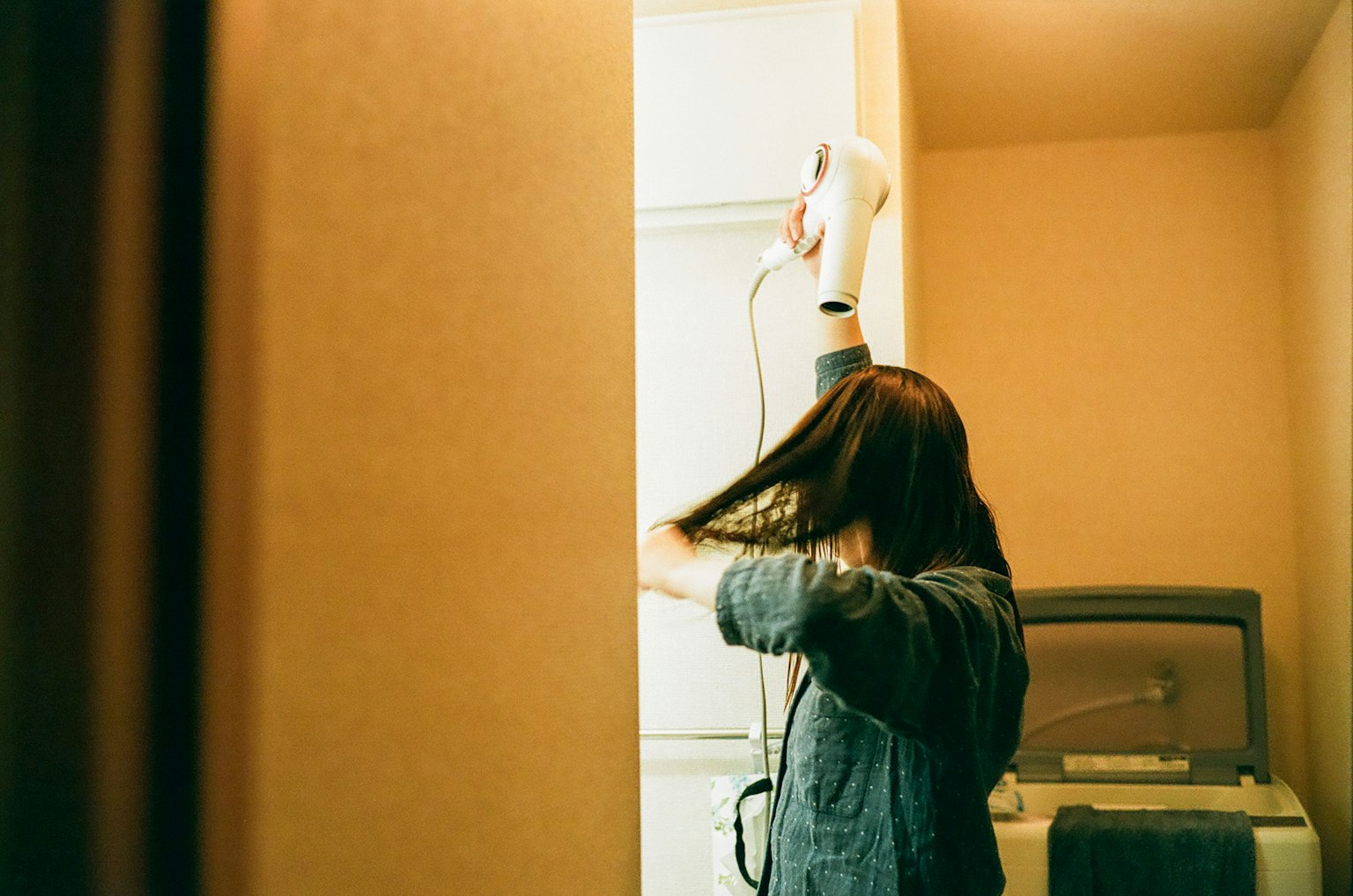 Mujer secándose el cabello en un baño