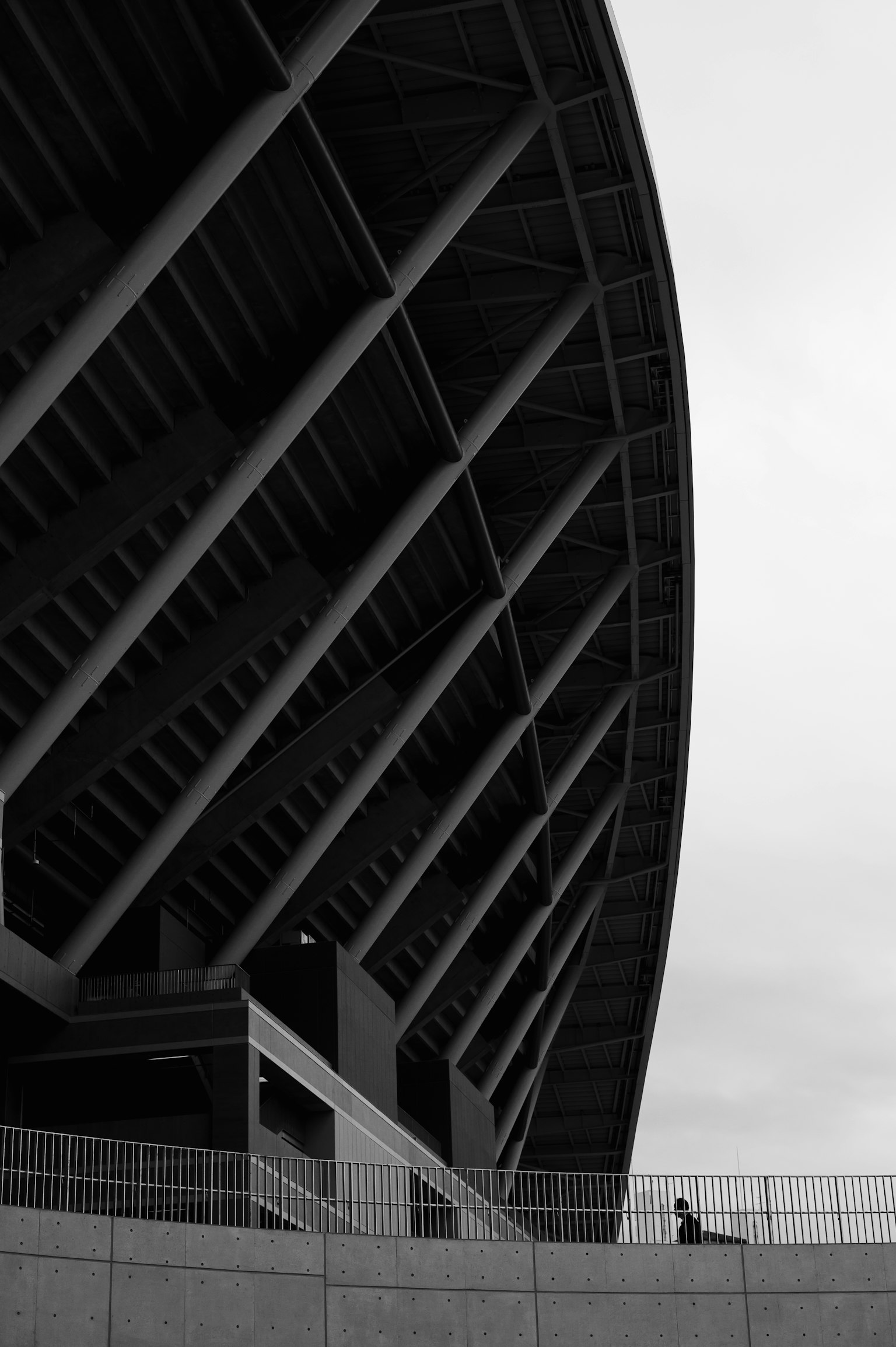 Gambar dekat struktur stadion hitam putih dengan satu orang
