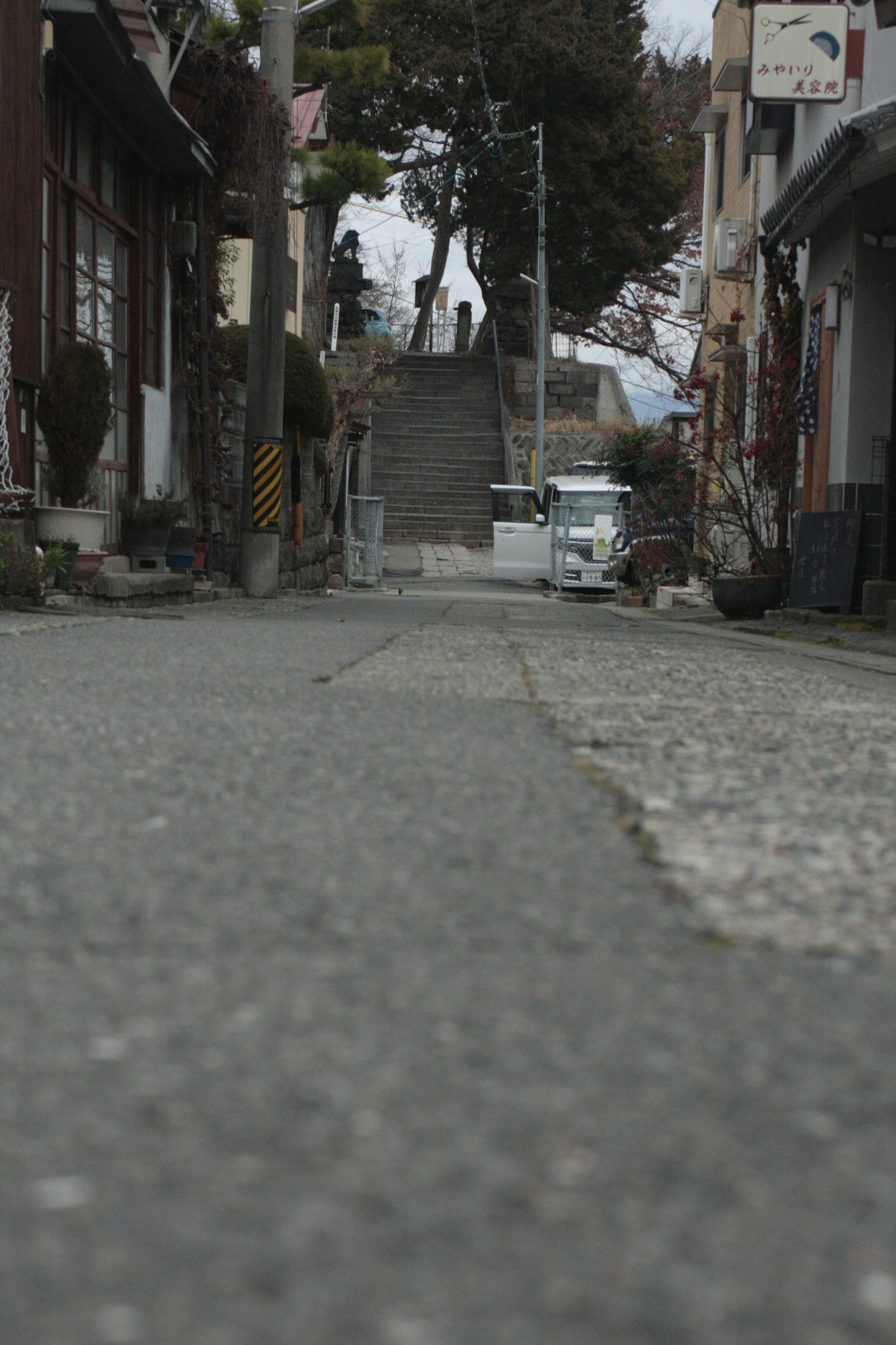 Escena de calle tranquila con camino de adoquines y escaleras visibles